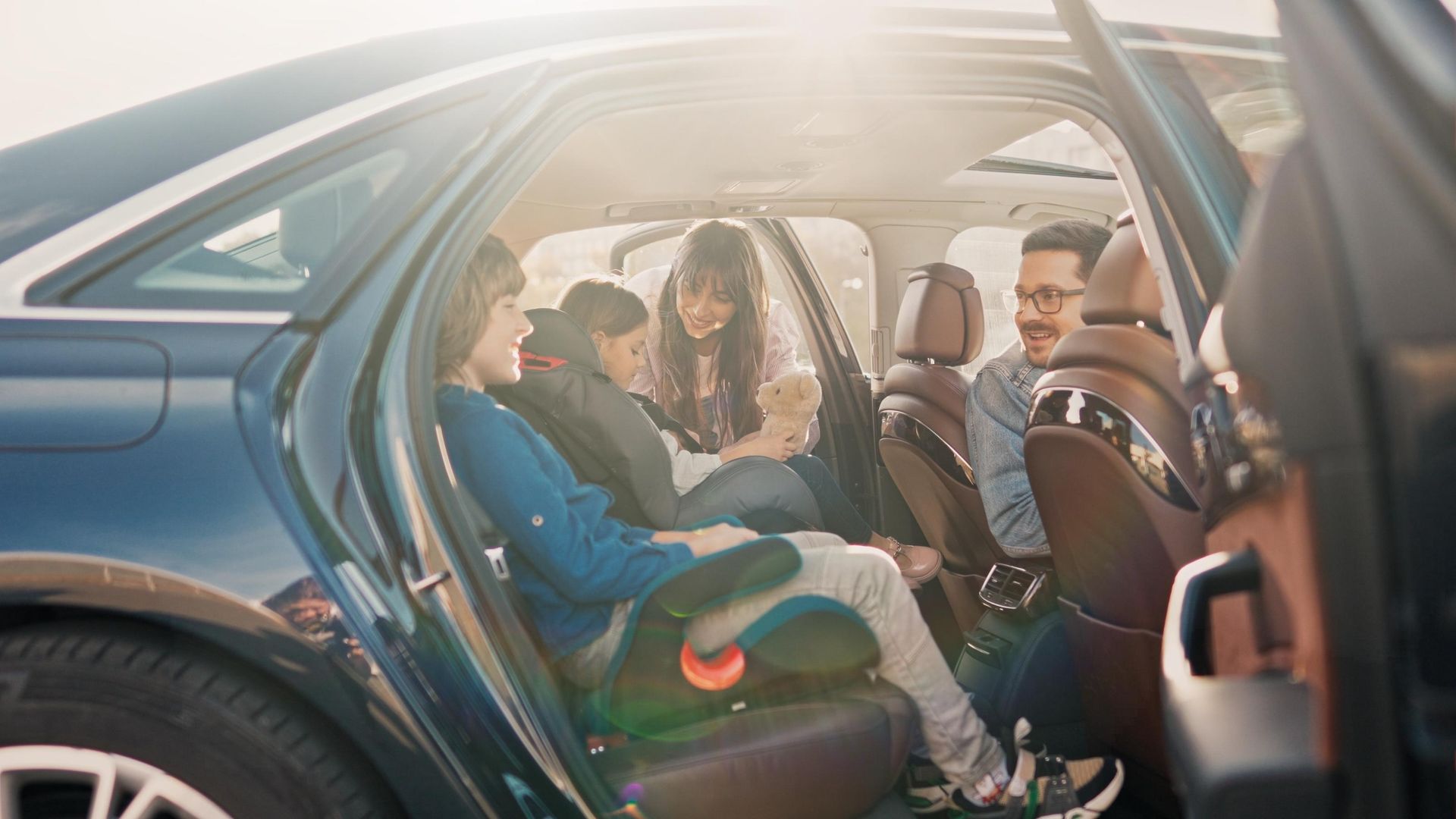 Family inside a car: adults and children. 