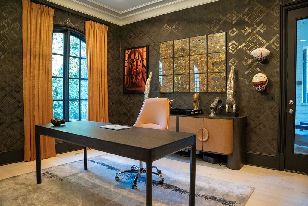 Office with black desk, gold curtains, patterned wallpaper, artwork, and cabinet.