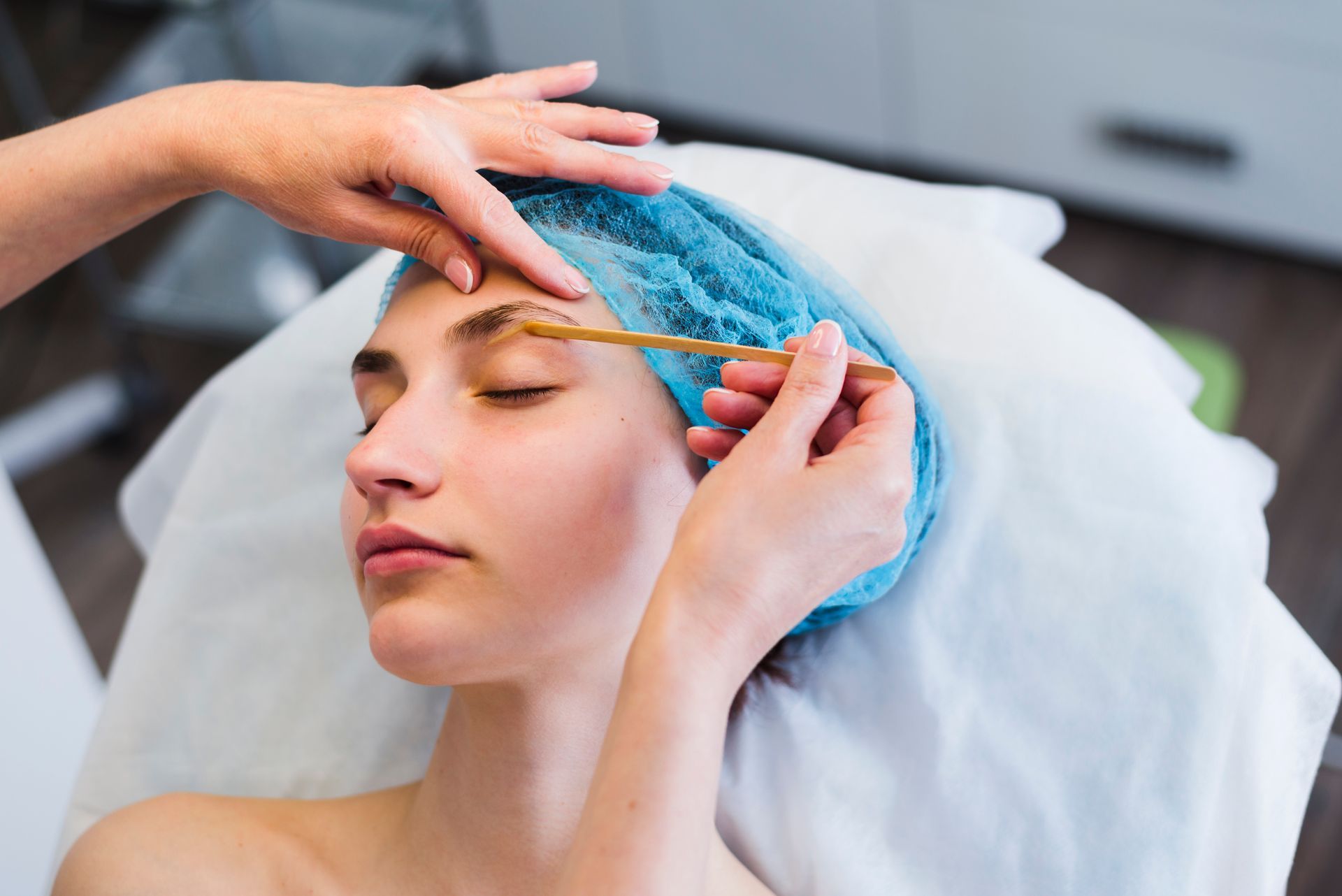 A woman is getting her eyebrows waxed.