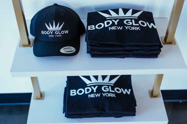 A woman is smiling and touching her face with her hand.