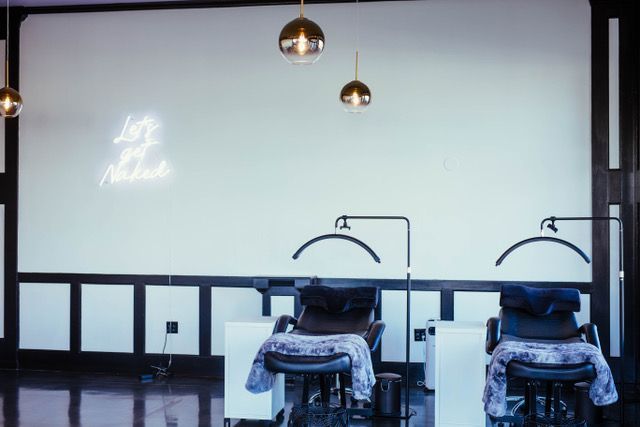 A room with a lot of chairs and a neon sign on the wall.