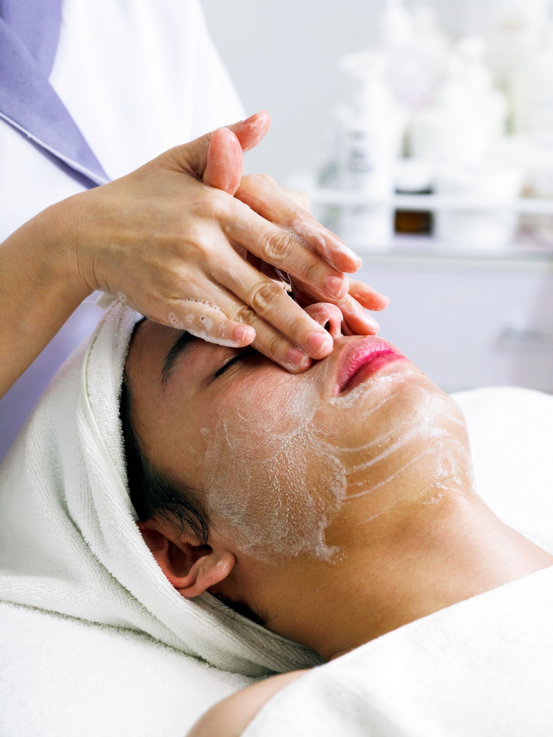 A woman is getting a facial treatment at a spa