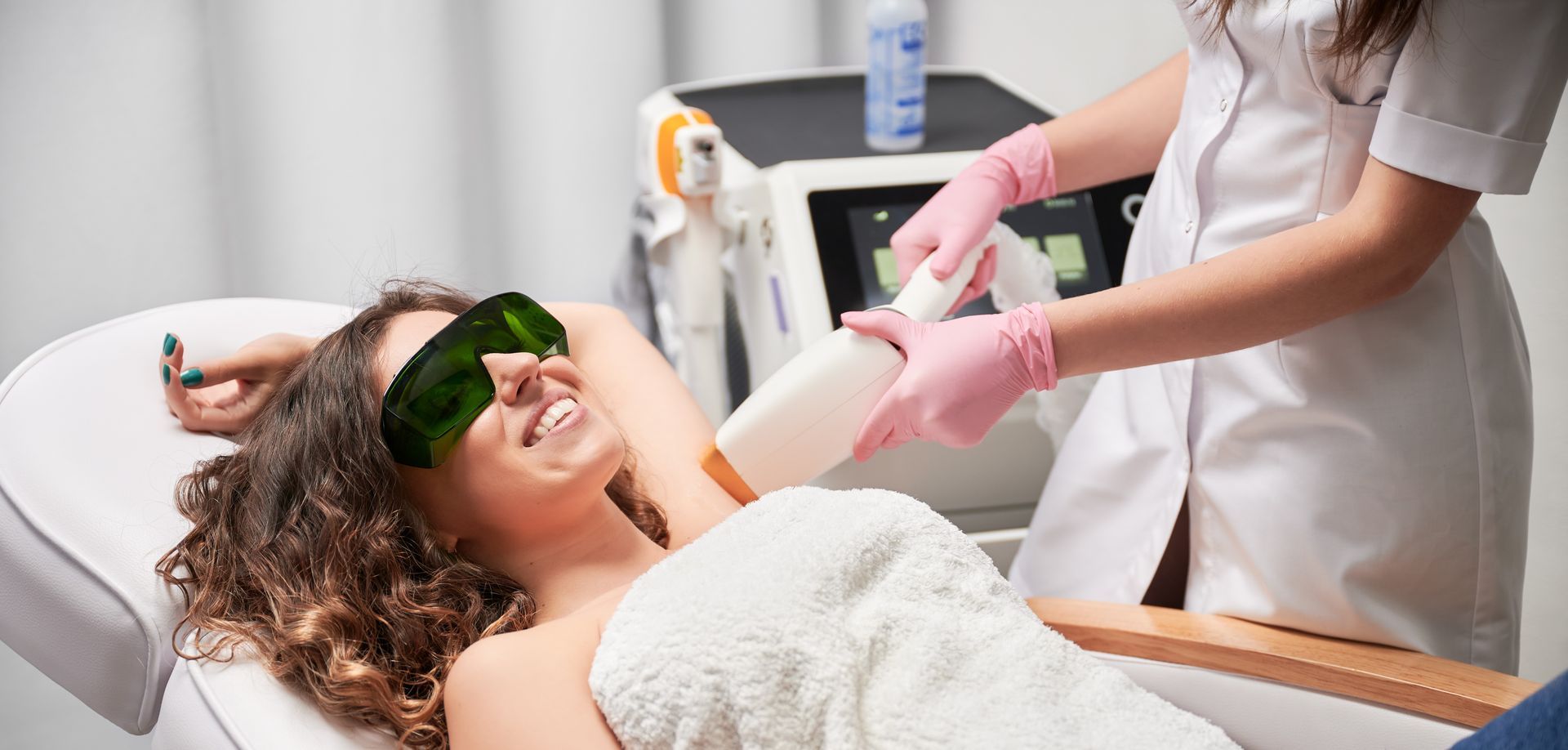 Woman receiving laser hair removal treatment on her underarm.