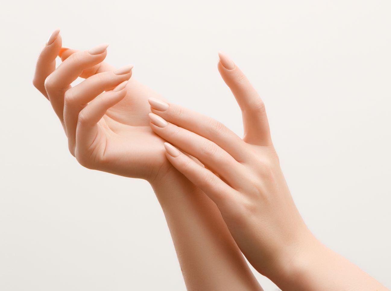 A close up of a woman 's hands on a white background.