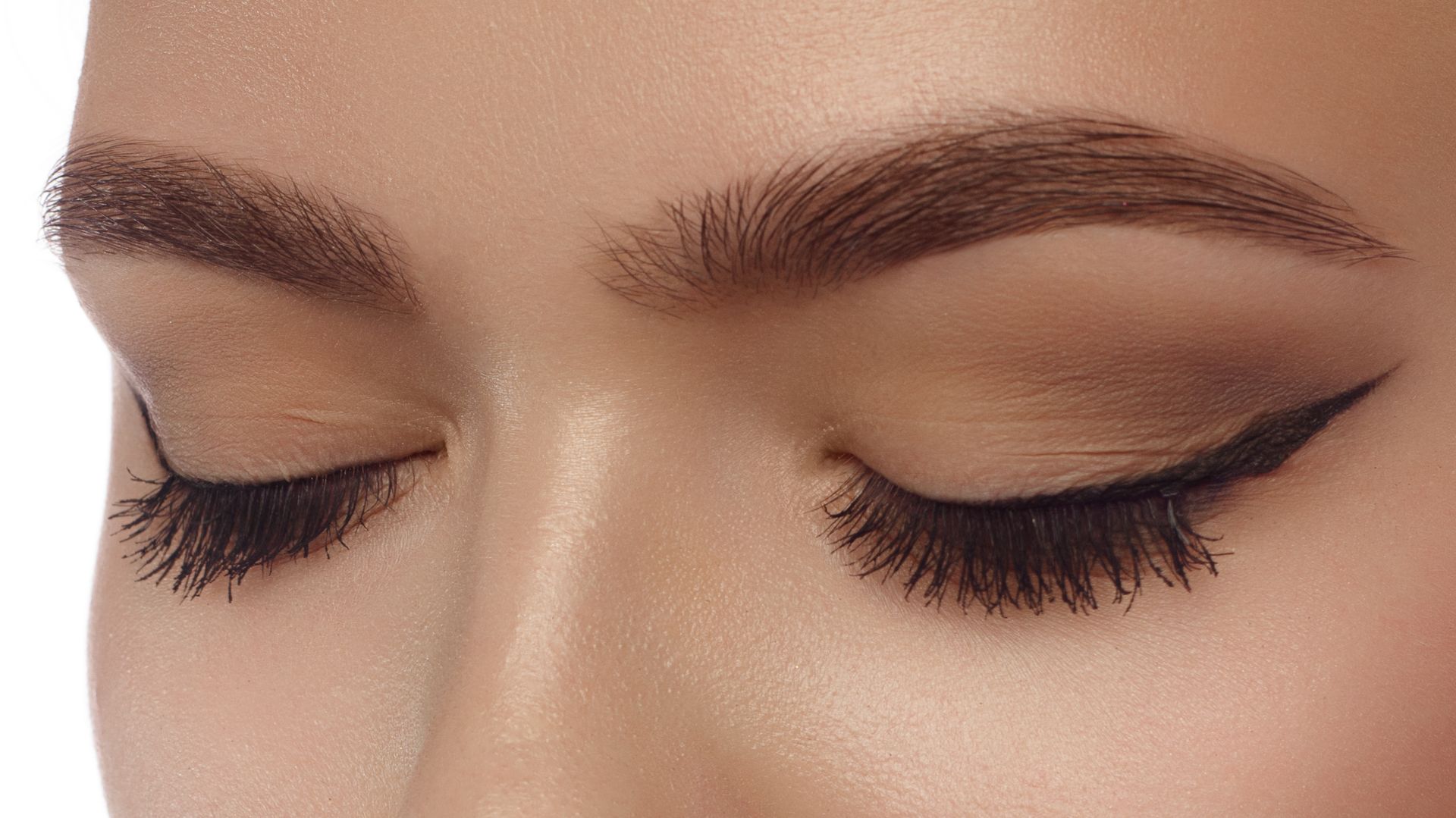 A close up of a woman 's eyes with long eyelashes and eyeliner.