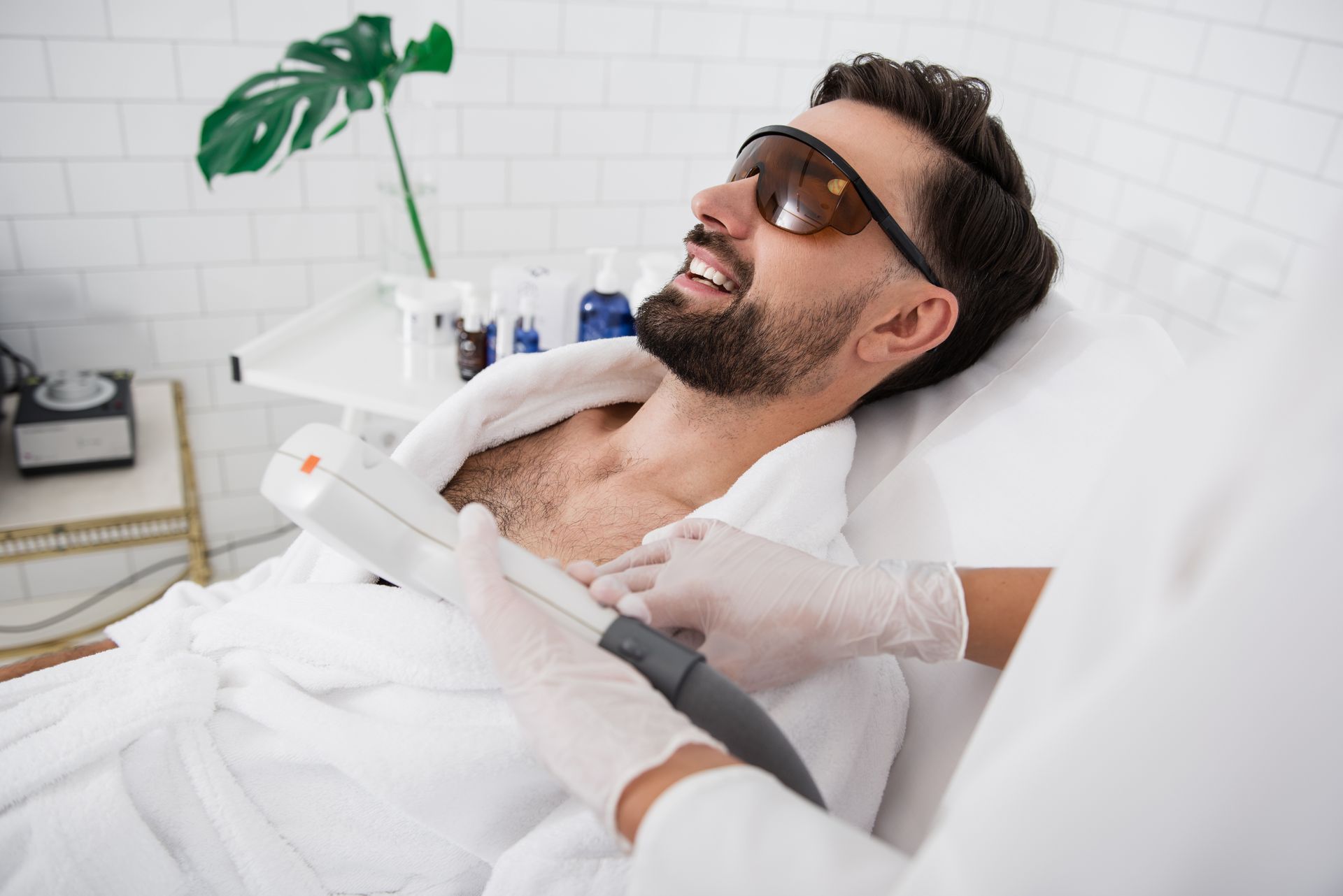 A man is getting a laser hair removal treatment on his chest.