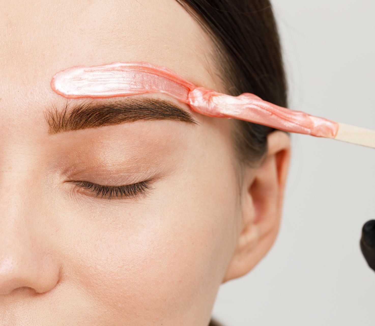 A woman is getting her eyebrows waxed in a beauty salon.
