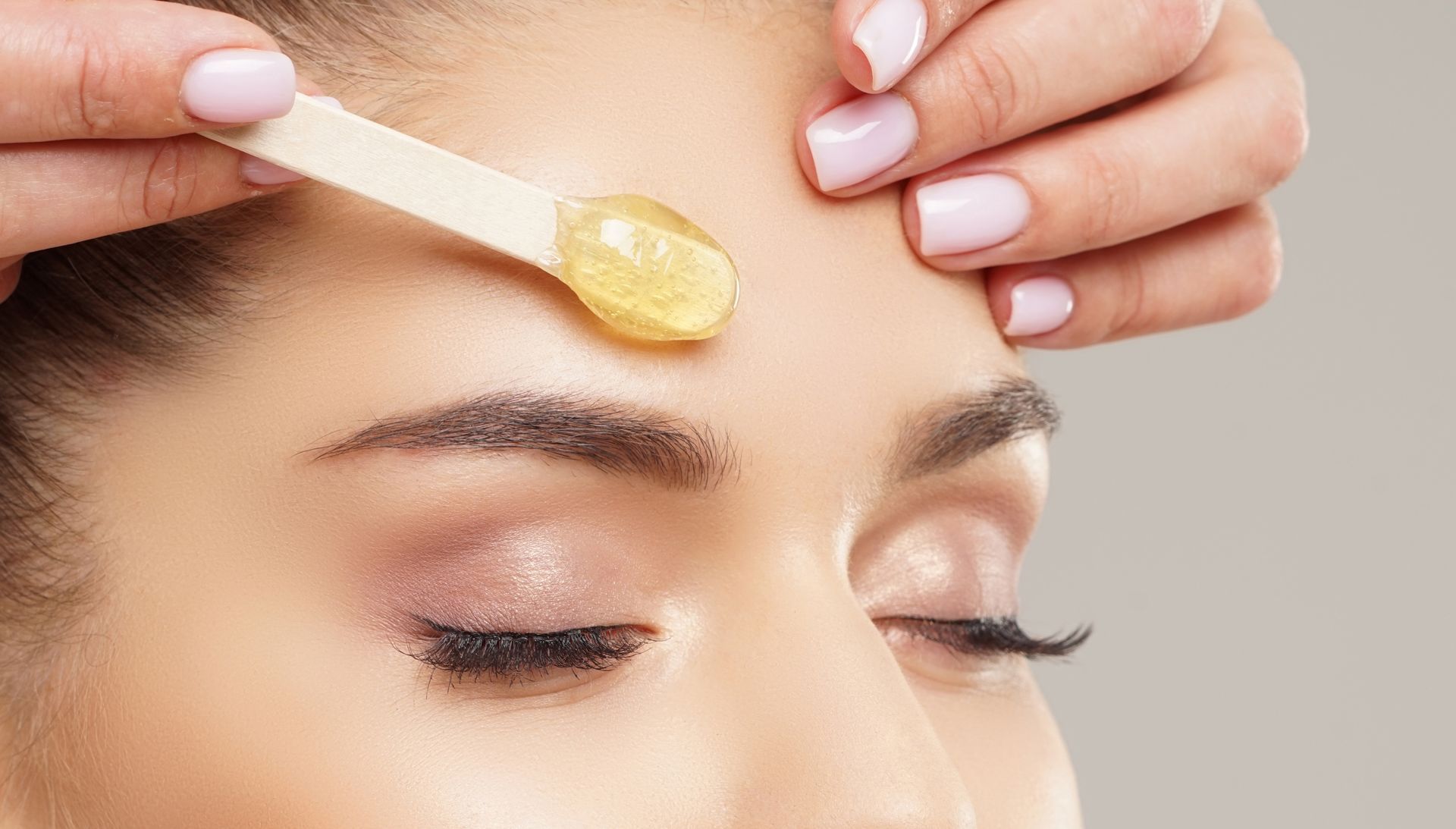A woman is getting her eyebrows waxed at a beauty salon.