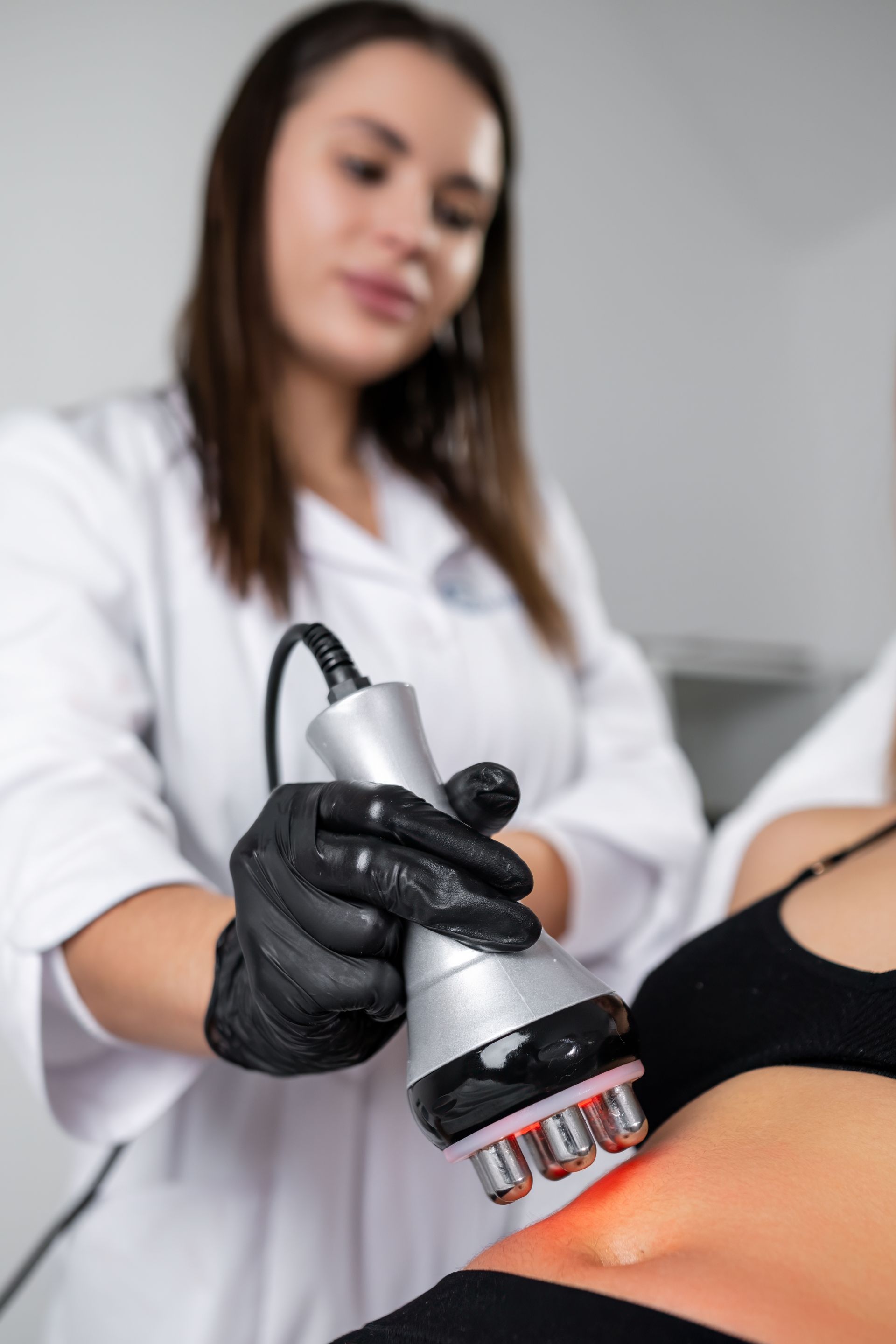 A woman is getting a cavitation treatment on her stomach.