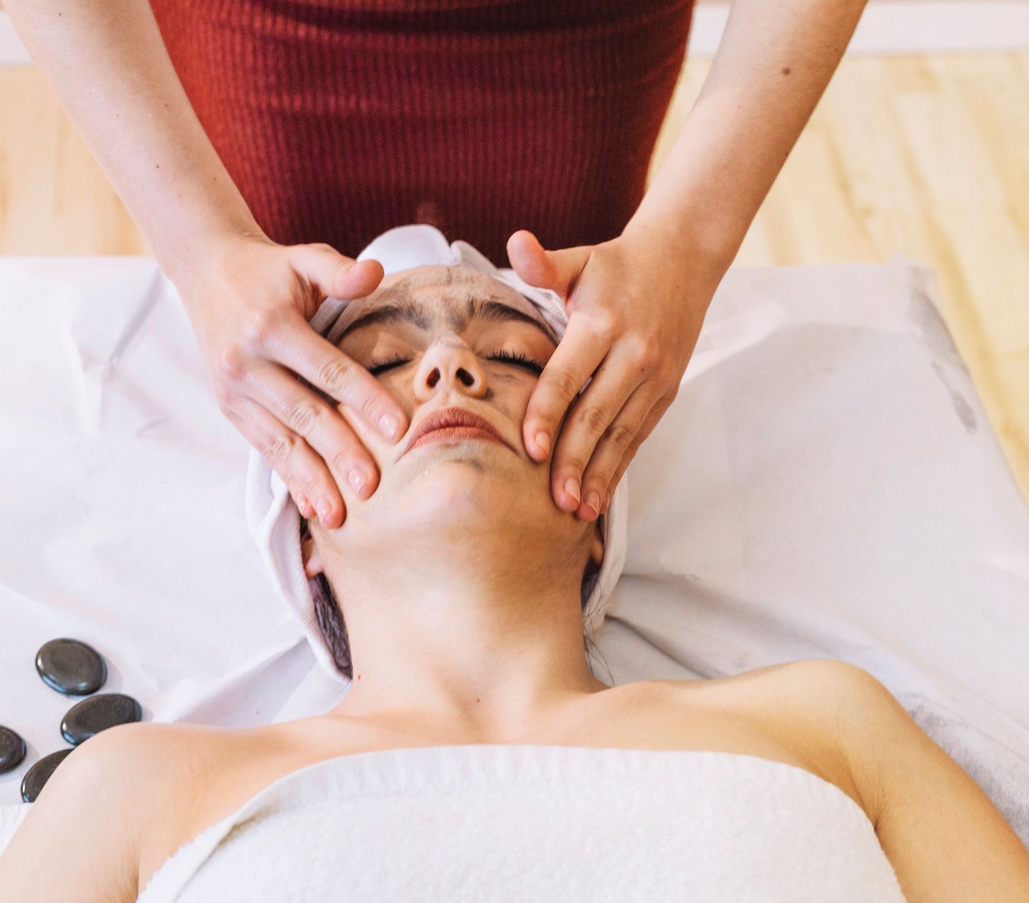 A woman is getting a facial massage at a spa.