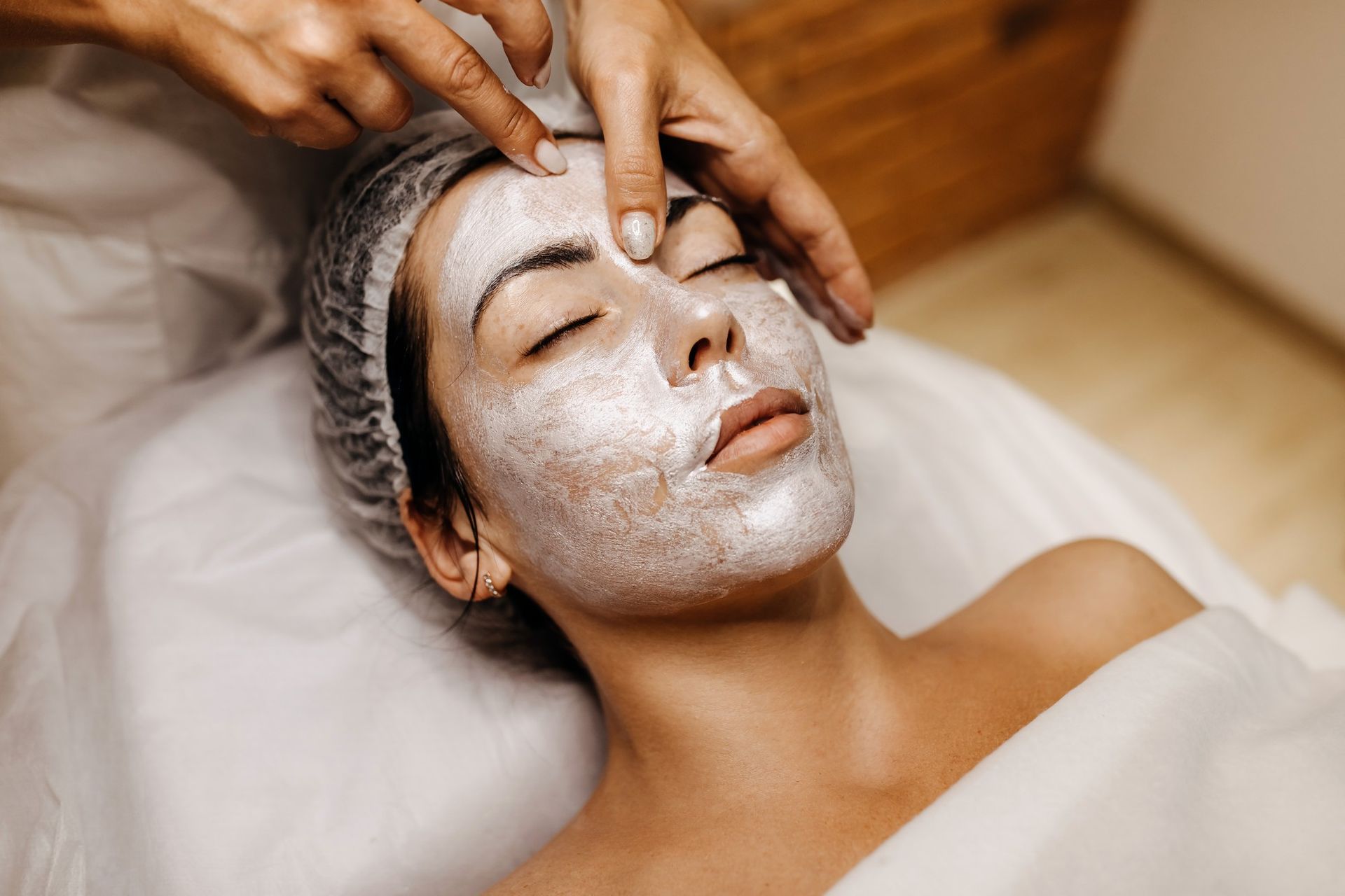 A woman is getting a facial treatment at a spa.