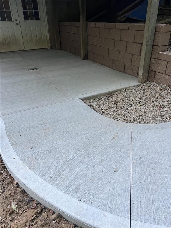 A concrete walkway with a brick wall in the background.