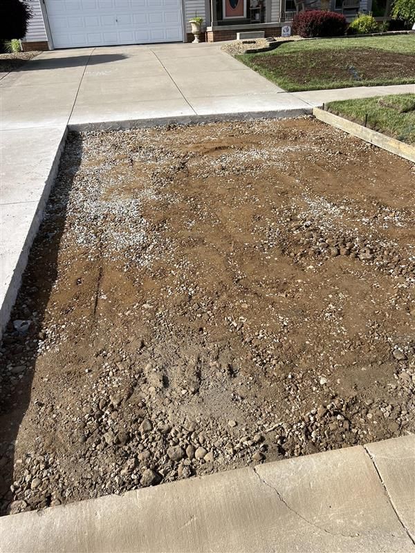 There is a lot of dirt in the middle of the driveway.