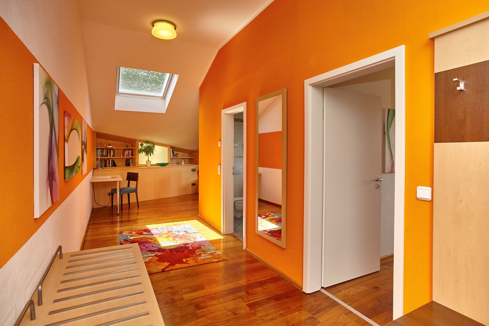 Ein Flur mit orangefarbenen Wänden und einem Spiegel an der Wand