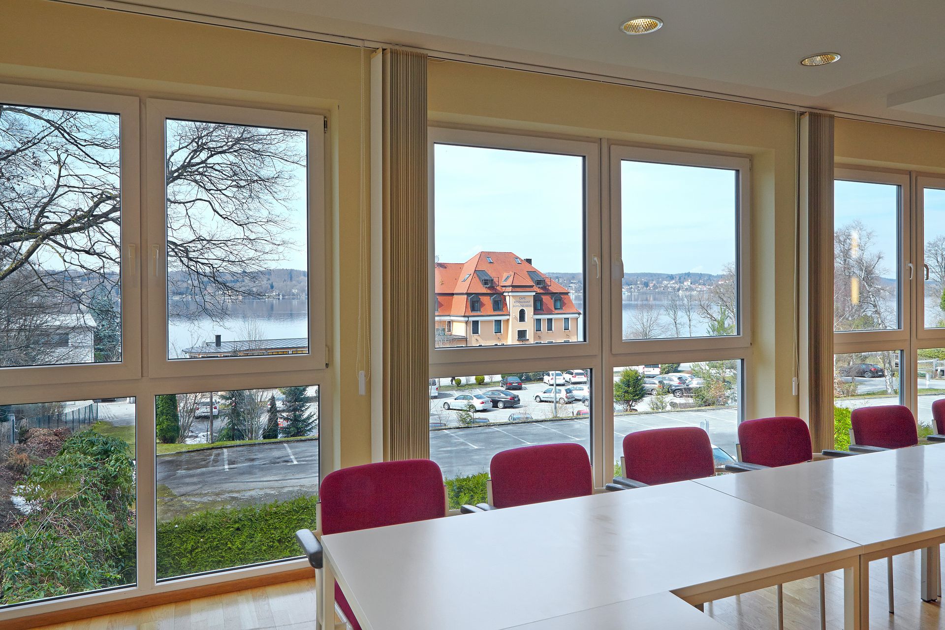 Ein Konferenzraum mit Tisch und Stühlen und vielen Fenstern