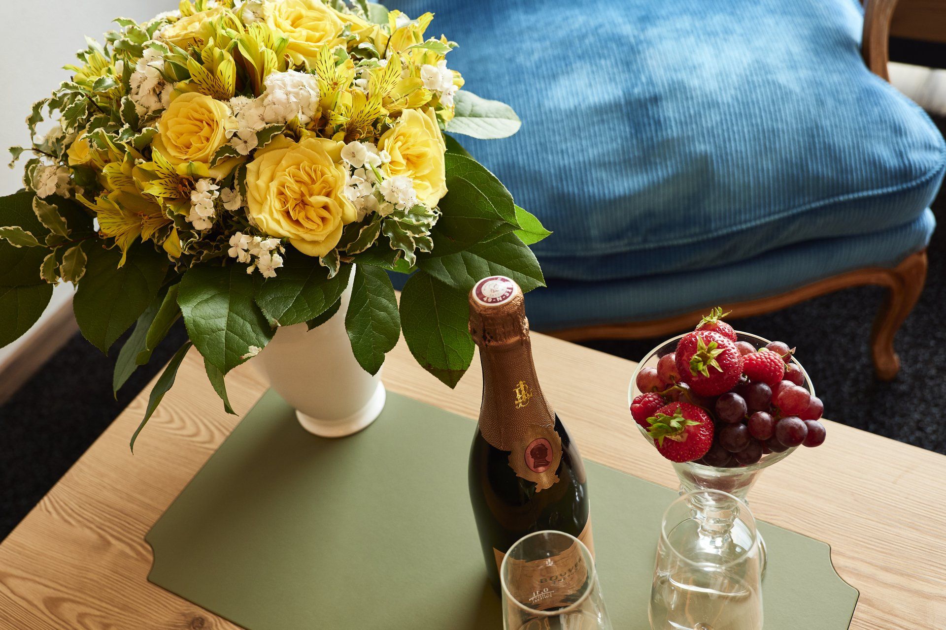 Ein Tisch mit einer Vase mit Blumen und einer Flasche Wein