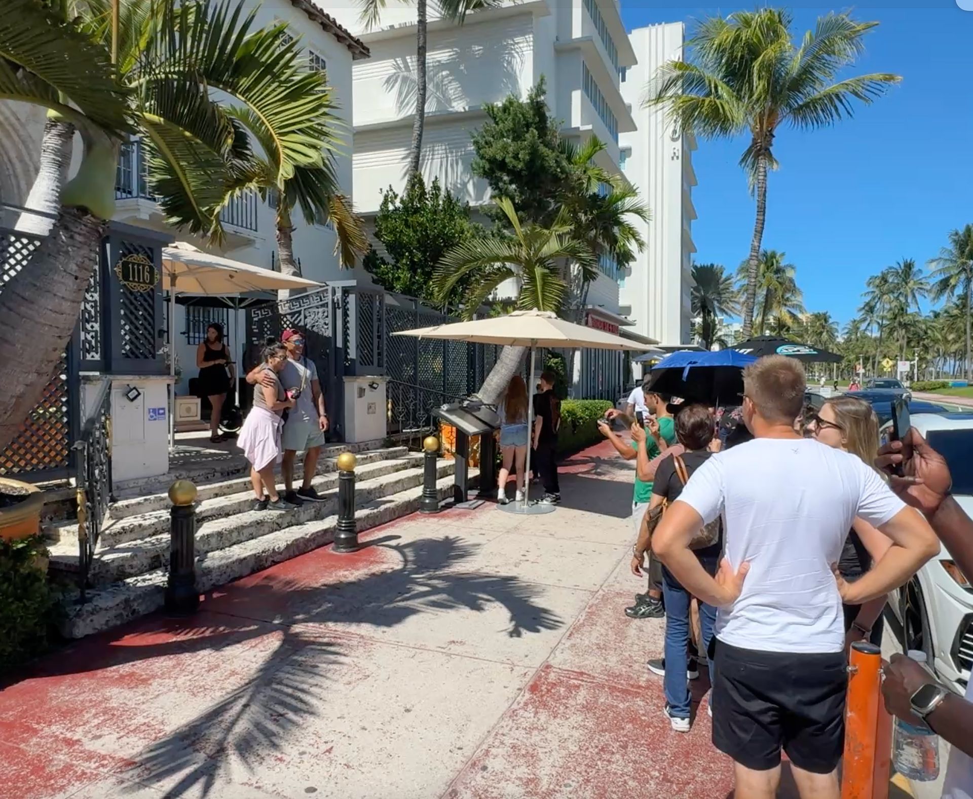 A few guests wait for they turn to take a photo in front of the Versace Mansion.