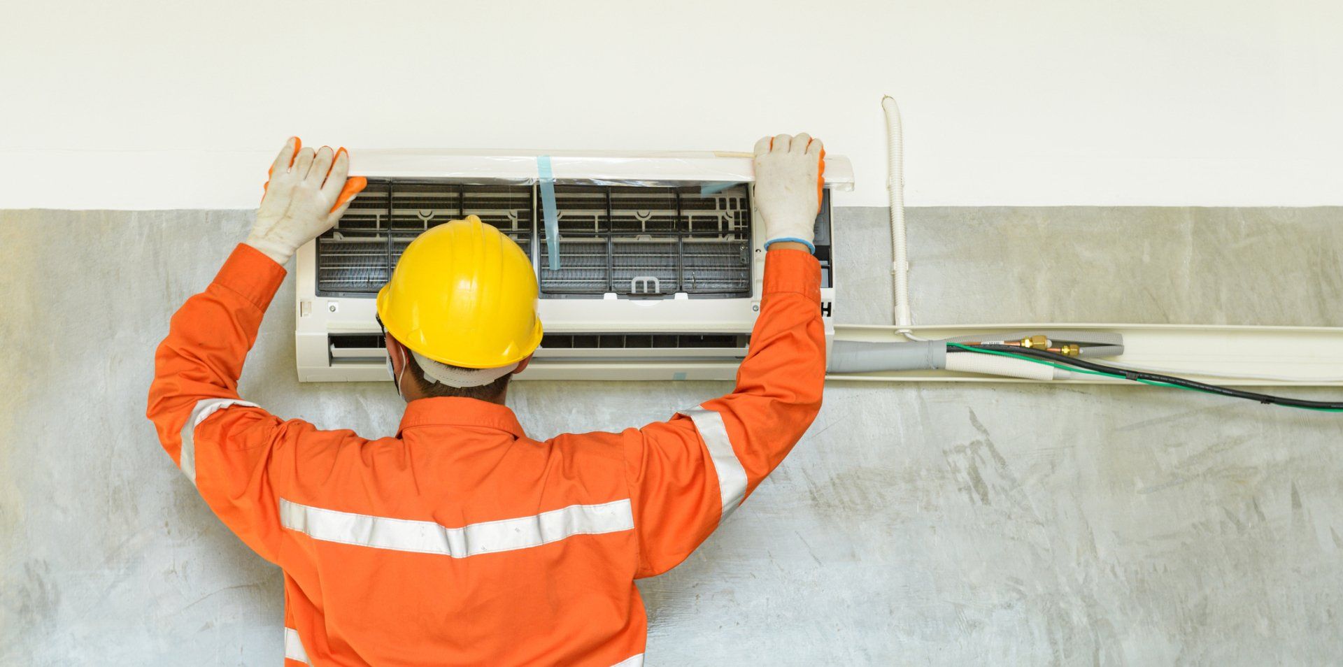 Technician Repairing Air Conditioner On The Wall — Vernal, UT — Airco Heating & Cooling Inc