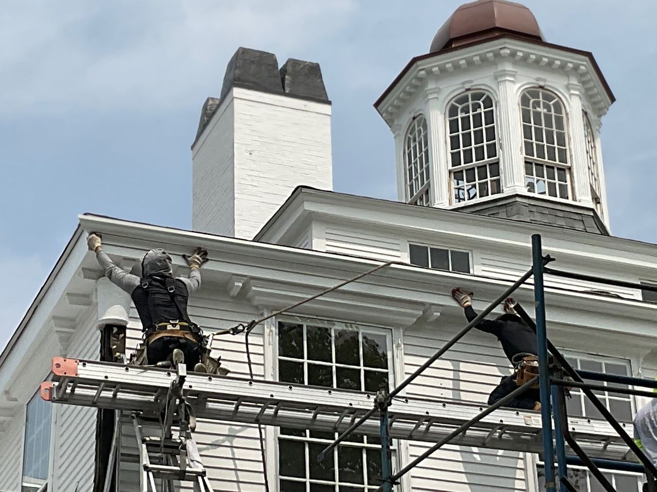 A group of people are working on the roof of a building.