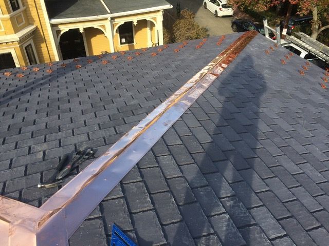 A roof with a copper gutter on it