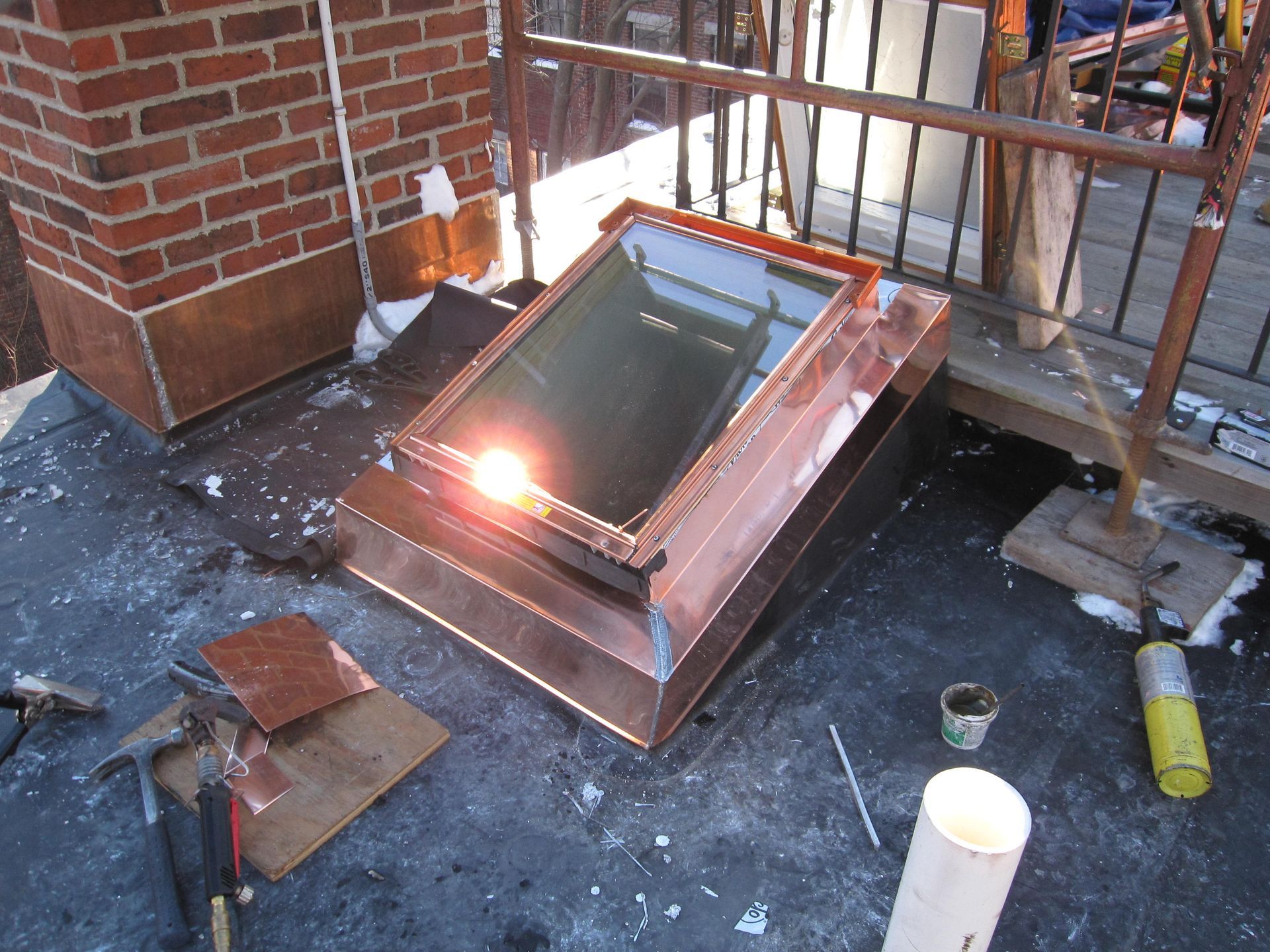 A copper skylight is being installed on the roof of a building