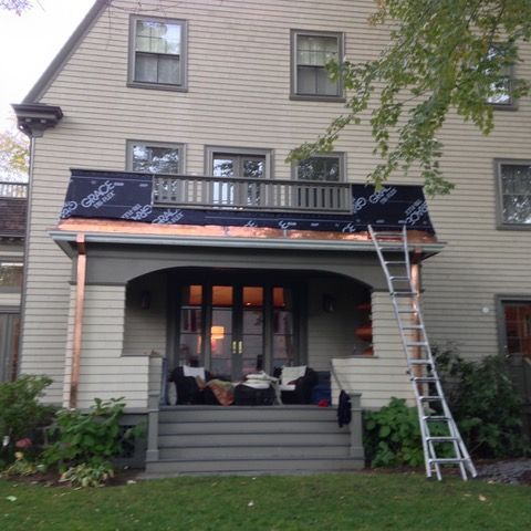 A house with a balcony and a ladder in front of it
