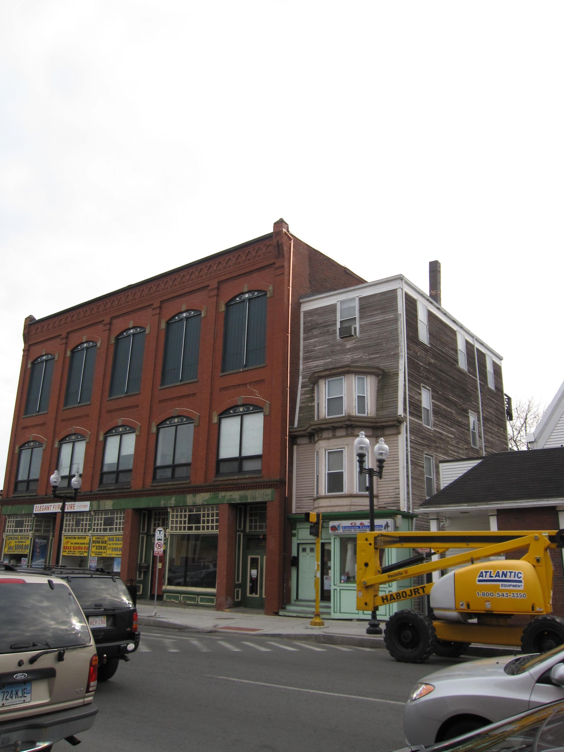 A large brick building with a yellow lift in front of it