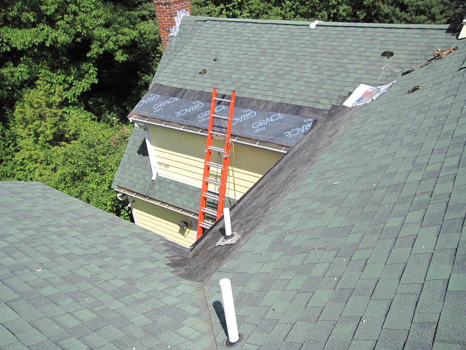 A ladder is sitting on the roof of a house