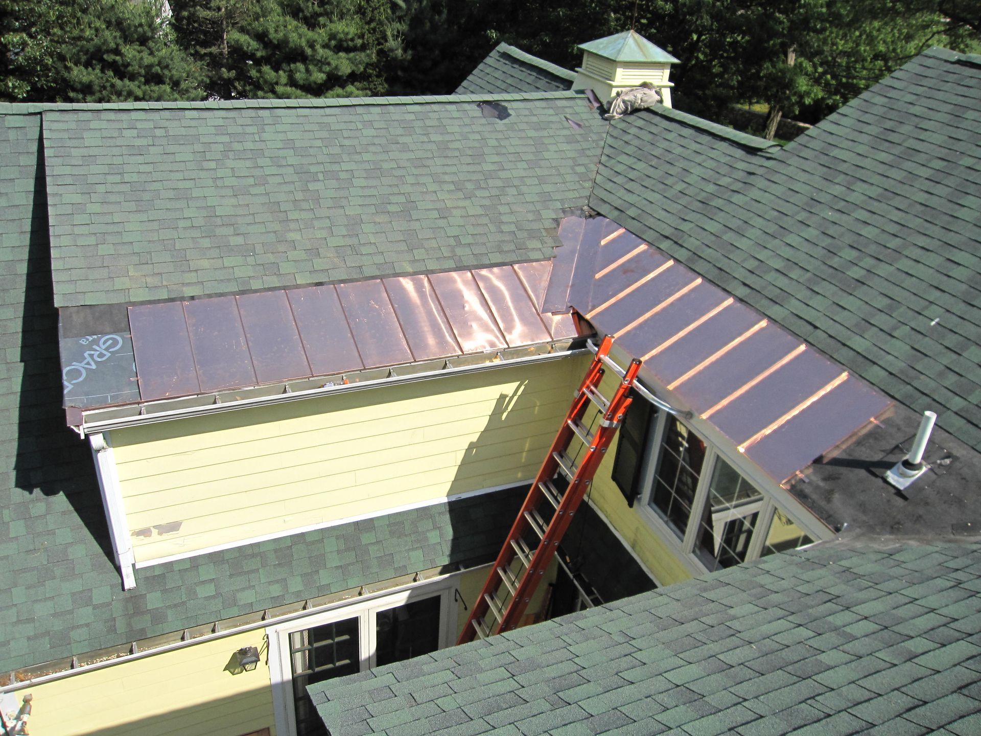 A ladder is sitting on the roof of a house