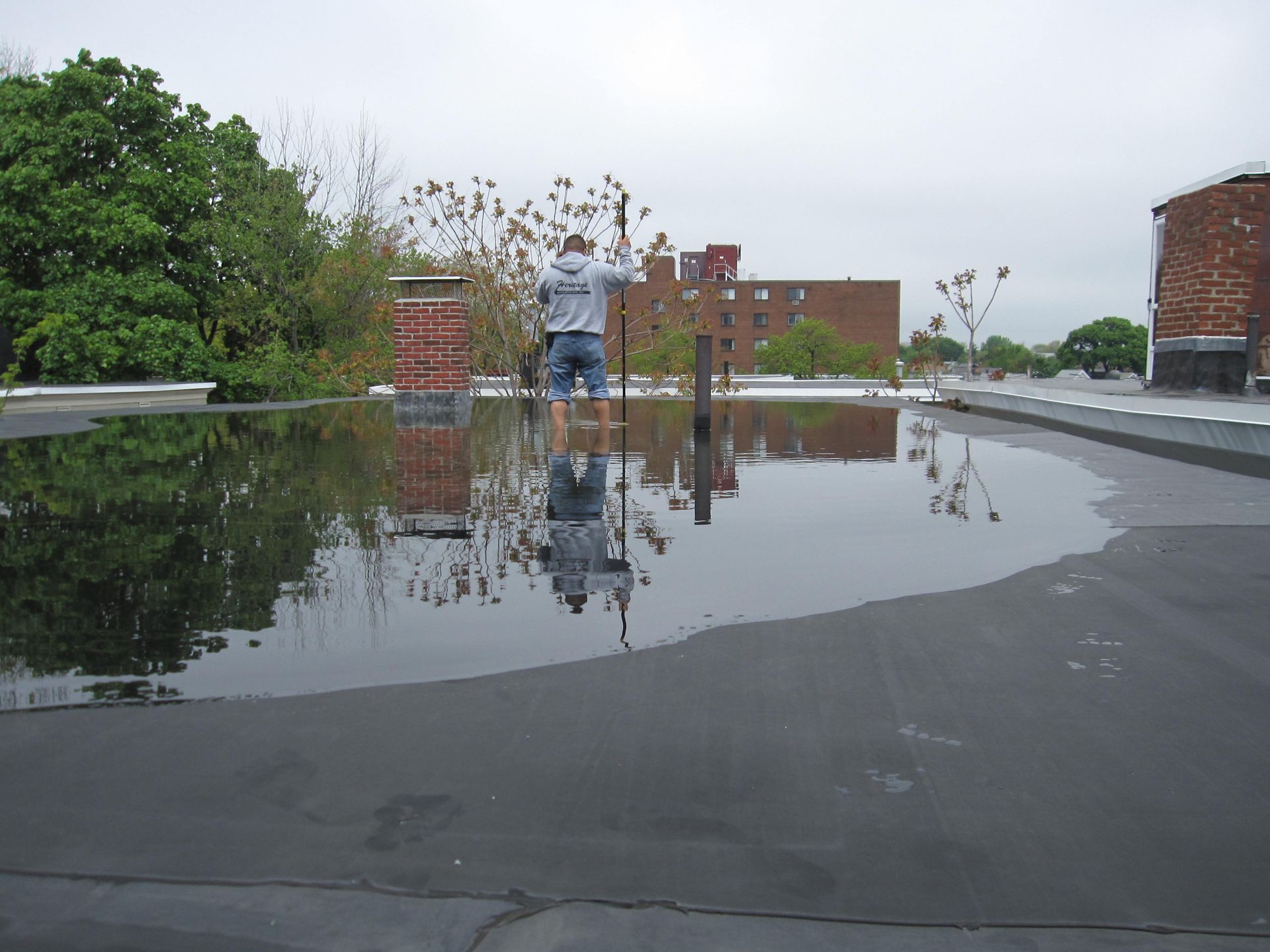 A man is standing in a puddle of water on a roof