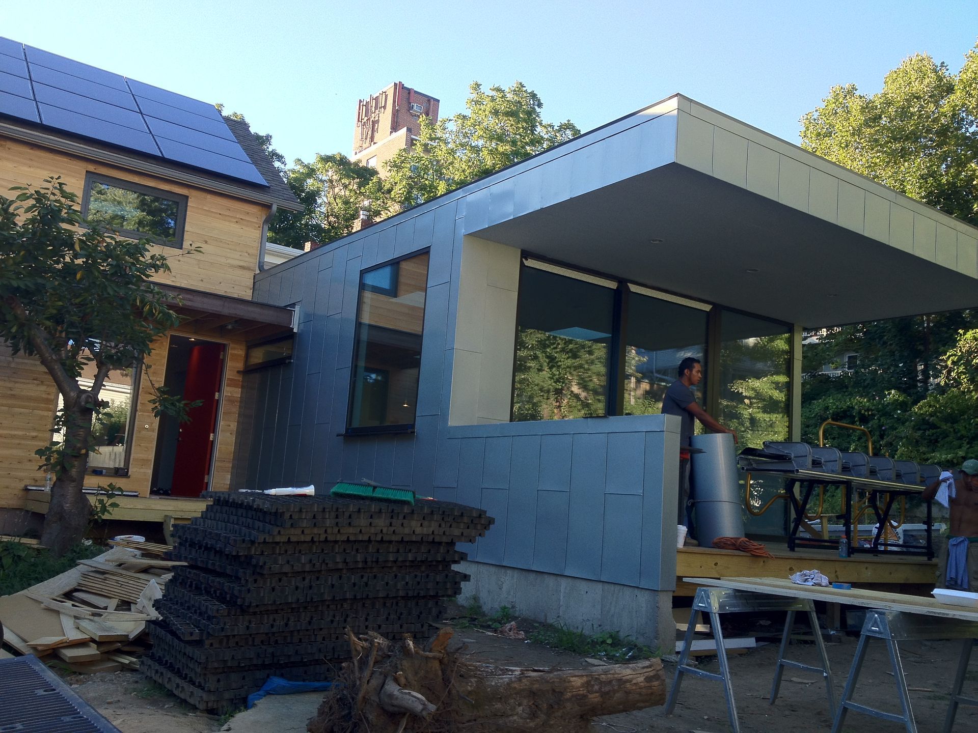 A man is standing in front of a house under construction
