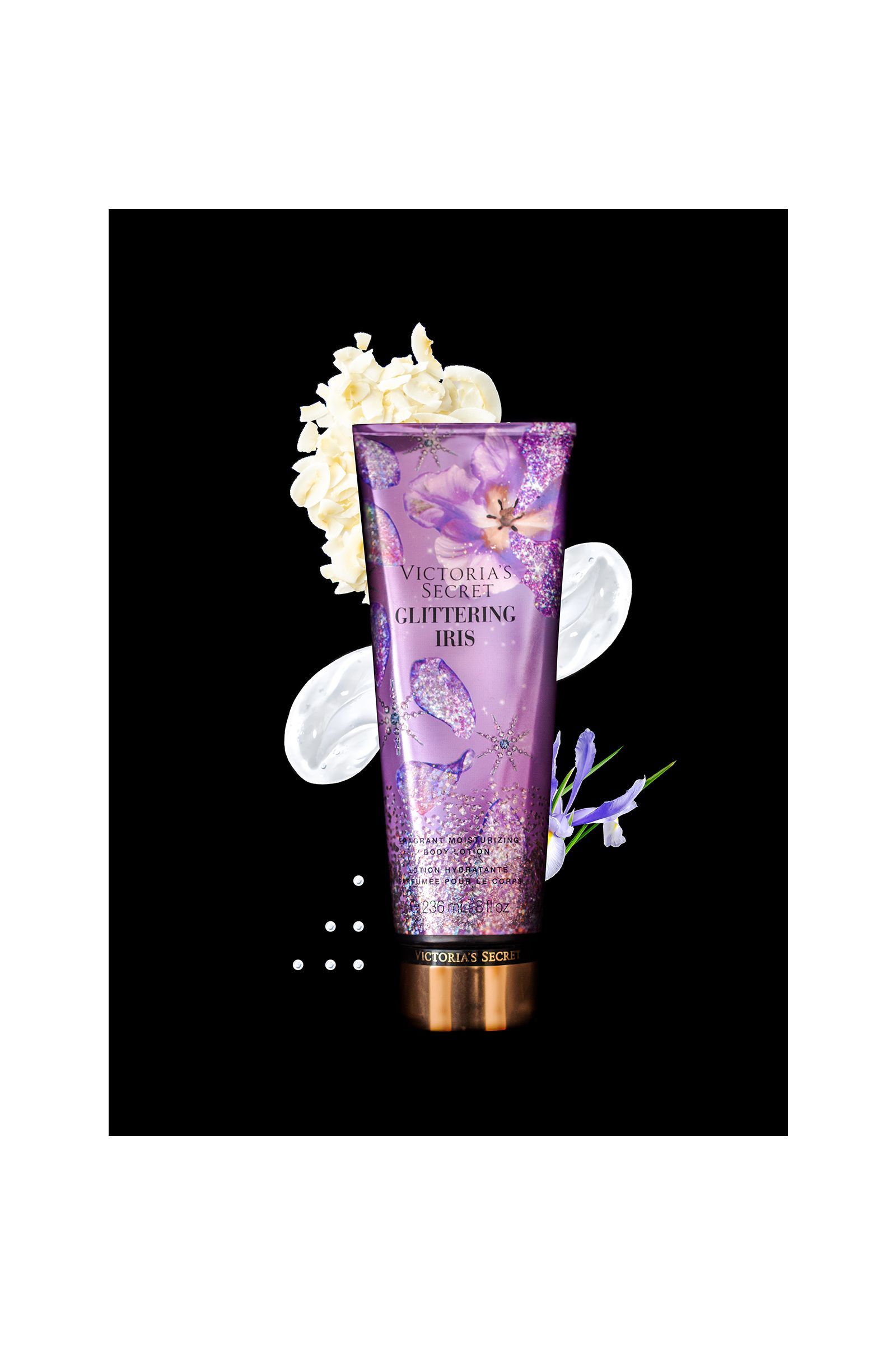 A purple bottle of lotion with flowers on it on a black background.