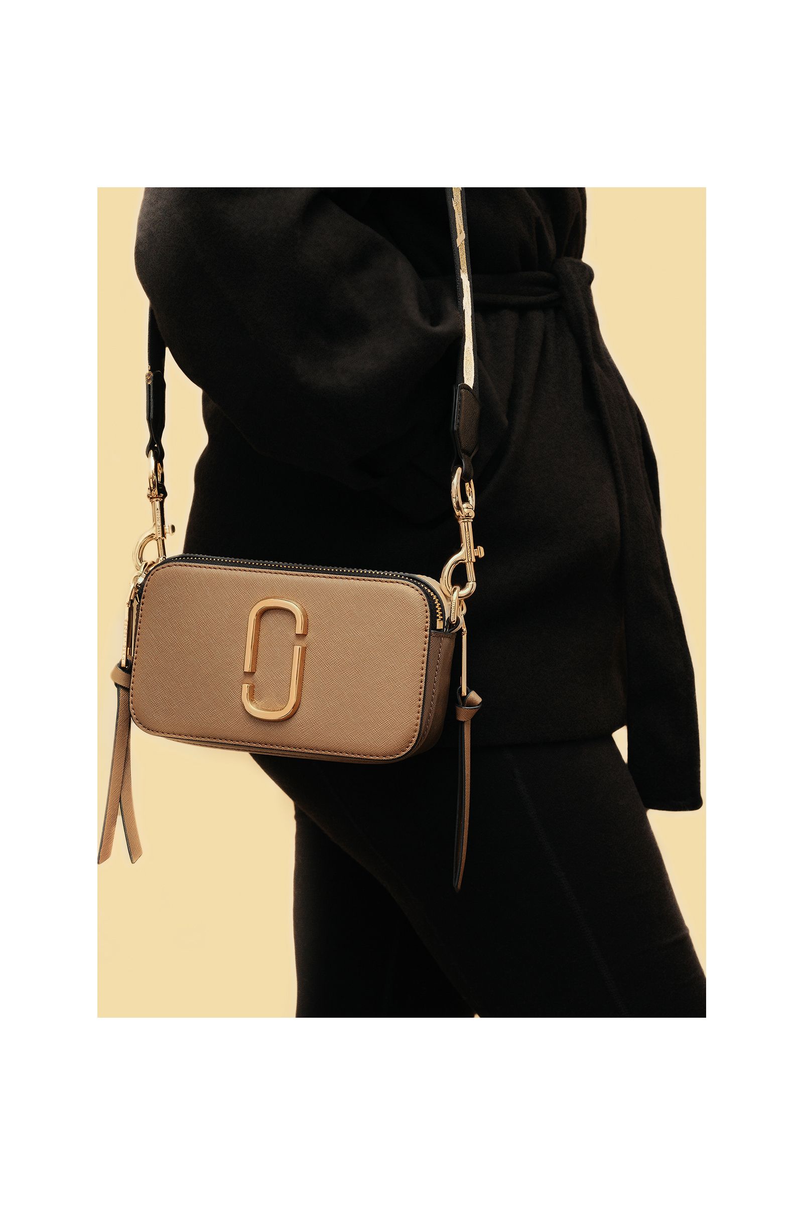 A person is wearing a black sweater and a brown purse.