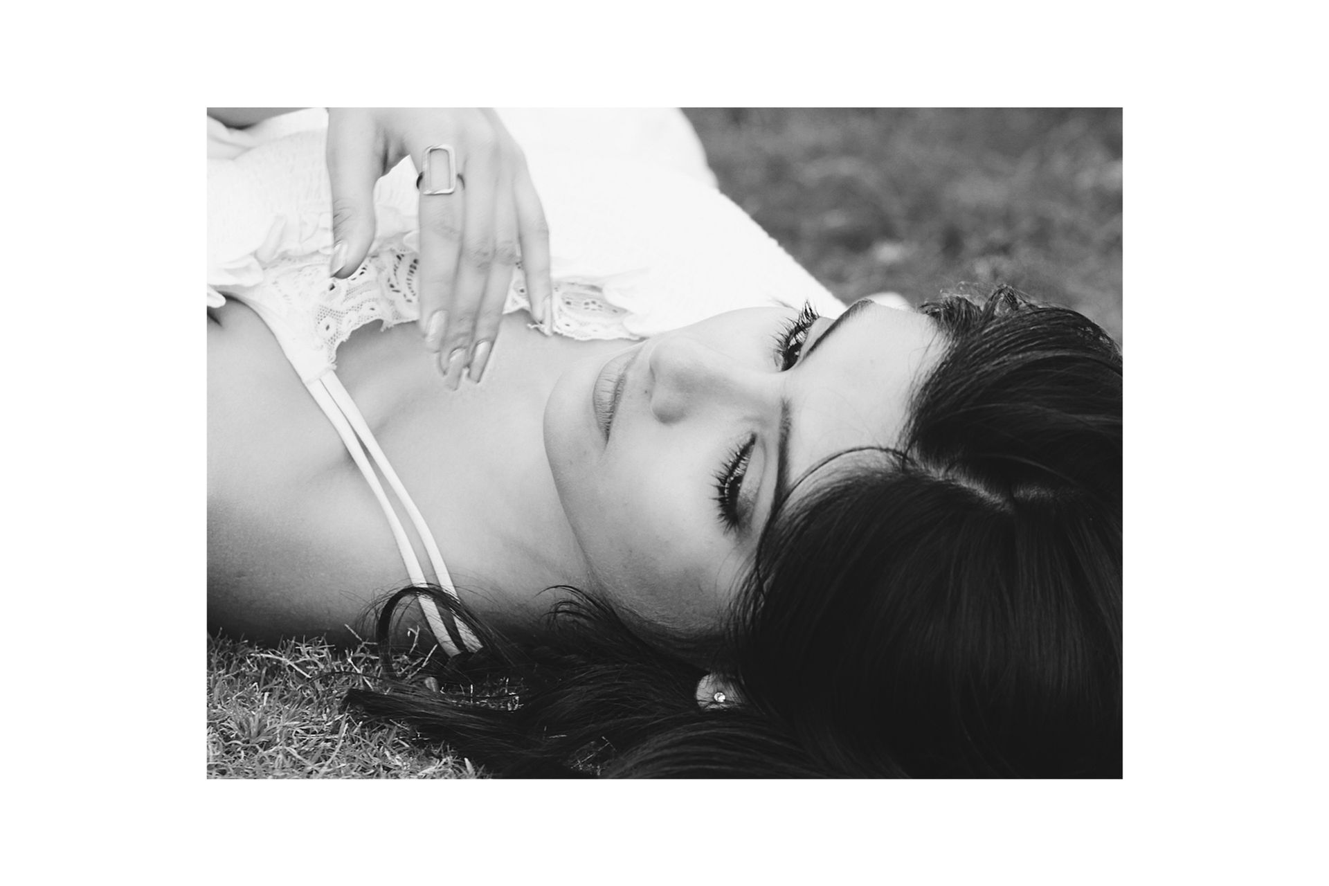 A black and white photo of a woman laying on the ground.