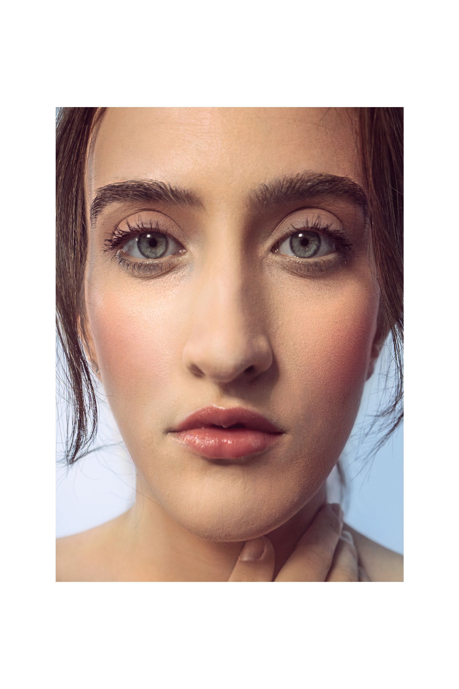 A close up of a woman 's face with a blue background.