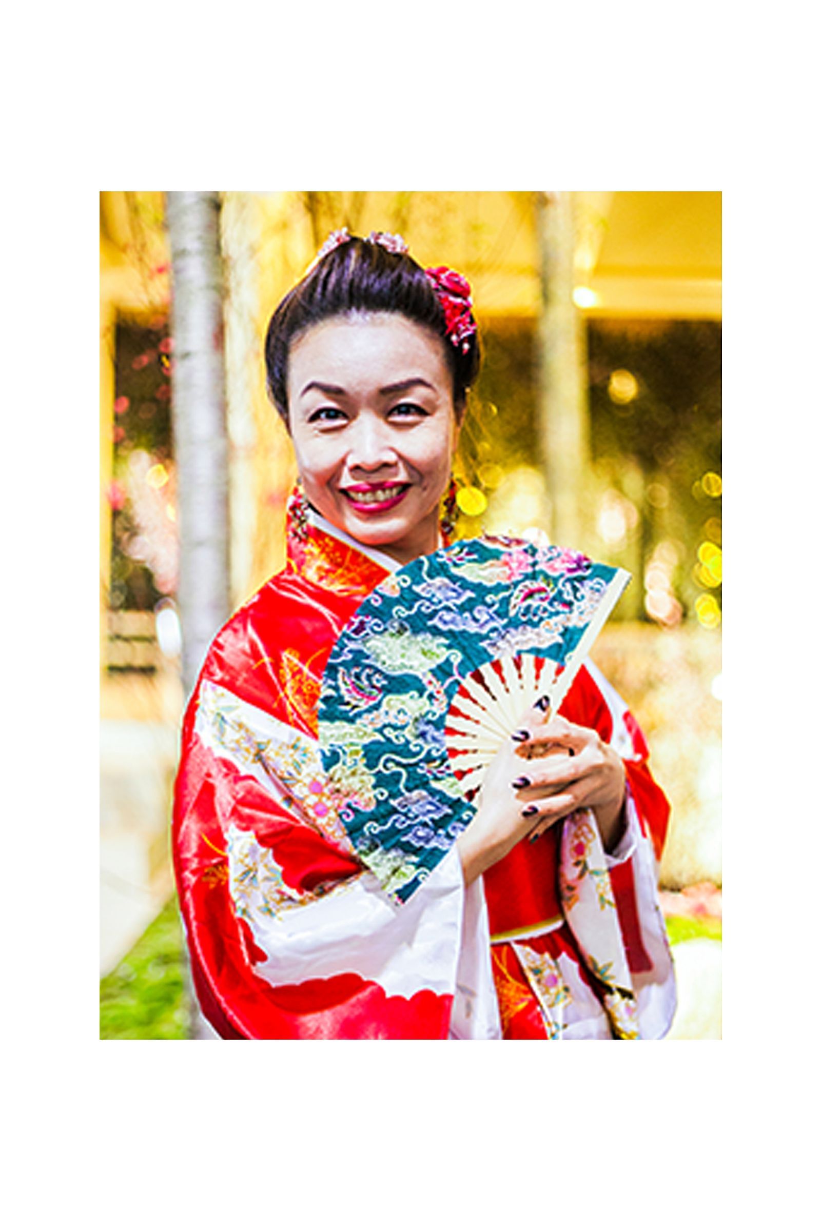 A woman in a red kimono is holding a fan.