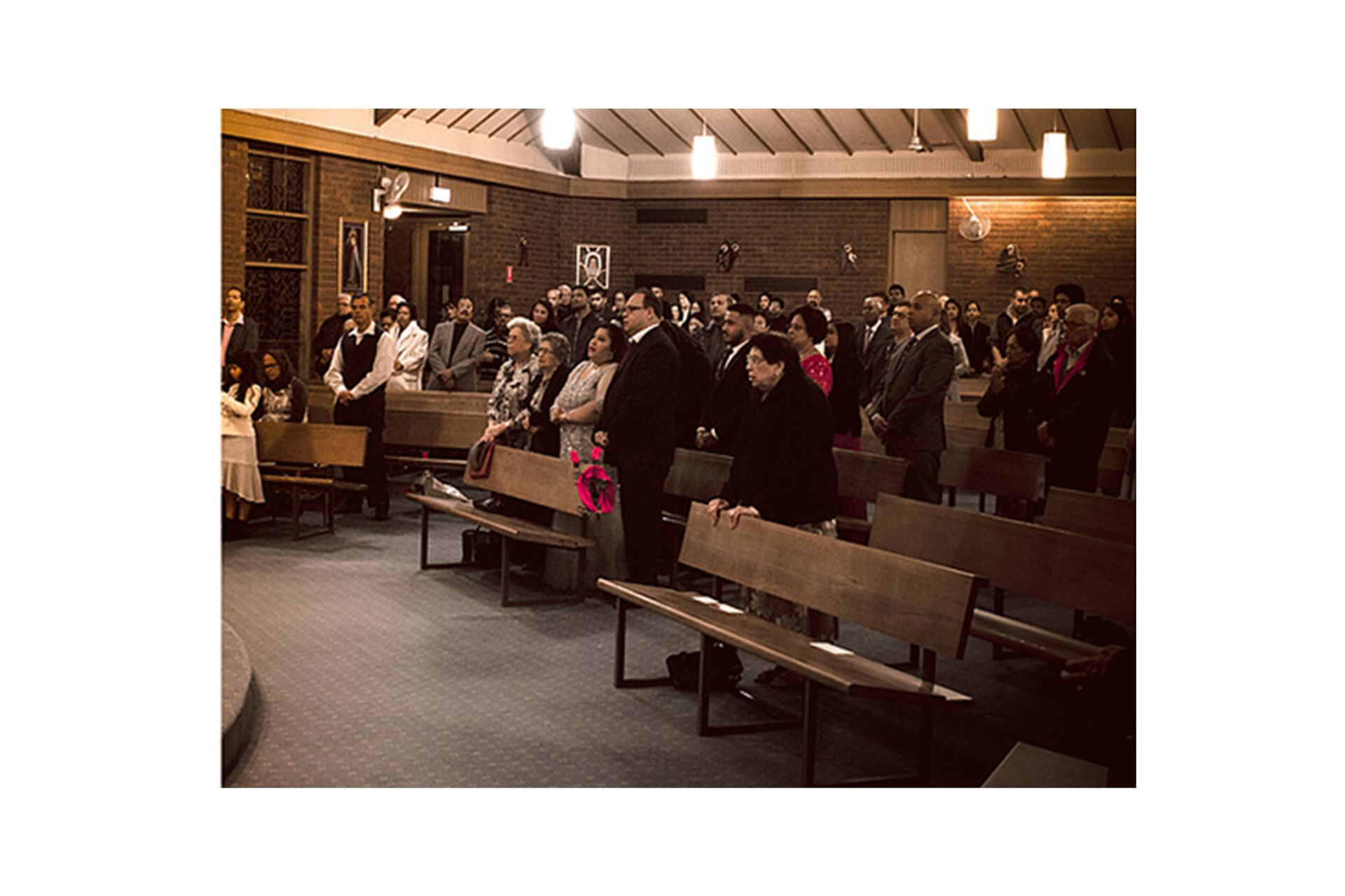 A group of people are sitting on benches in a church.