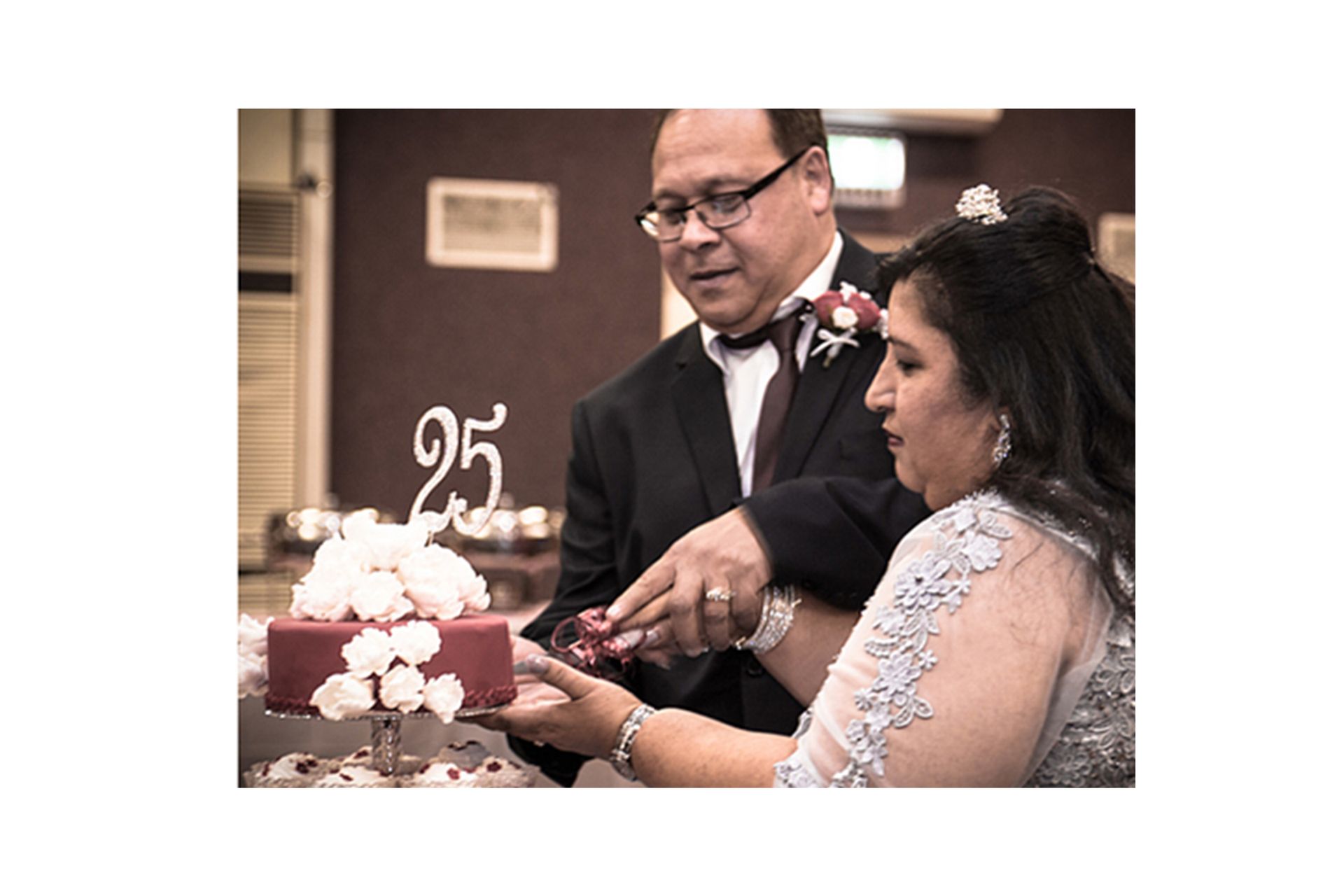 A man and a woman are cutting a wedding cake.