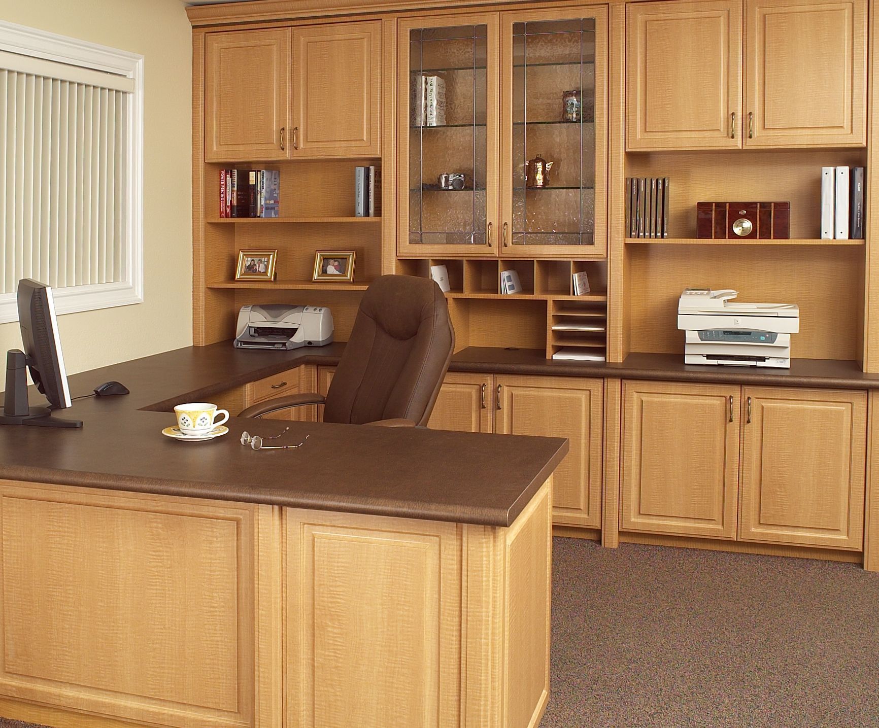 A desk with a computer and a chair in an office