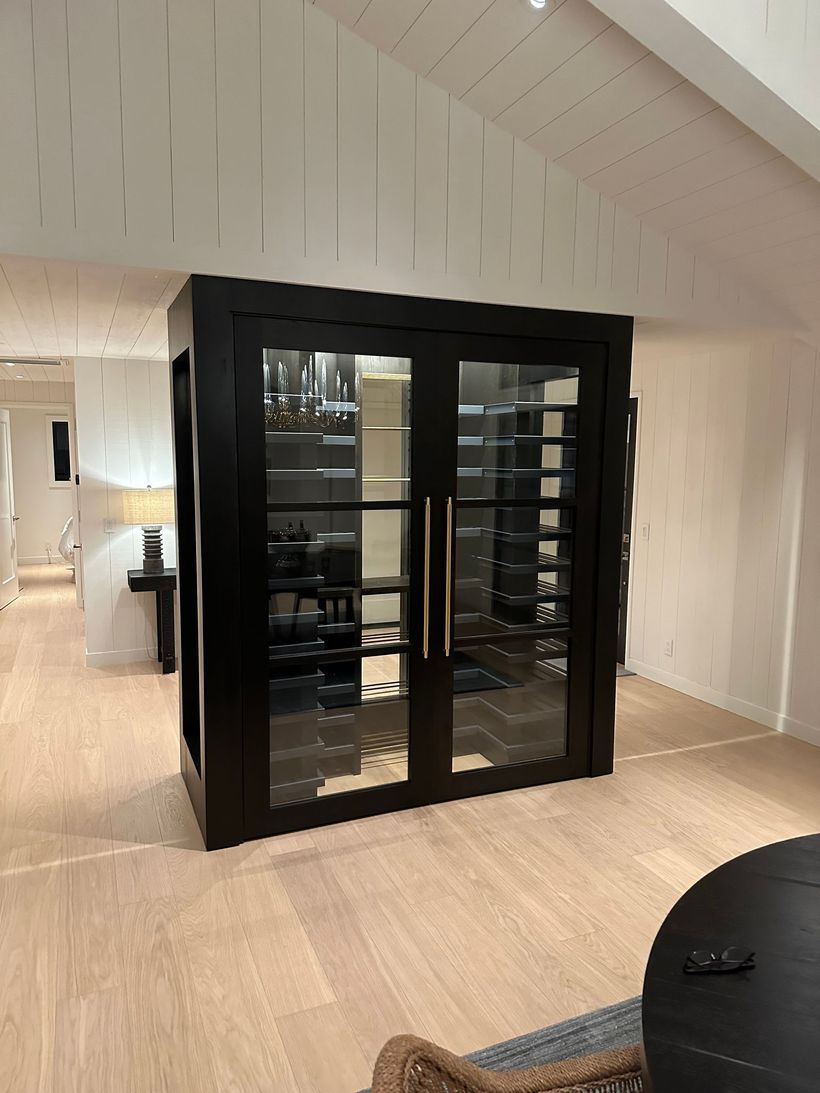 A large black cabinet with glass doors in a living room.