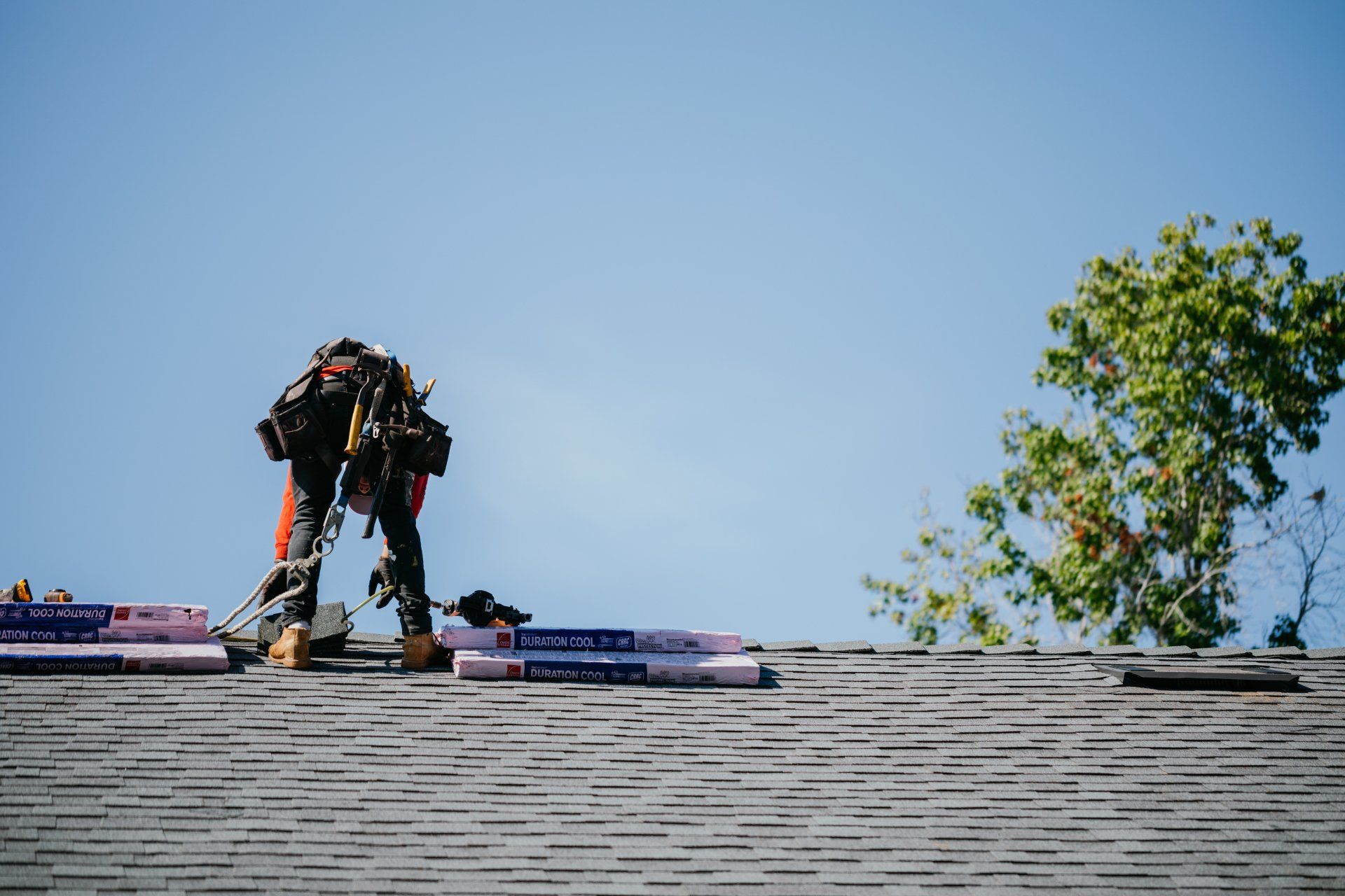 A man is working on the roof of a house