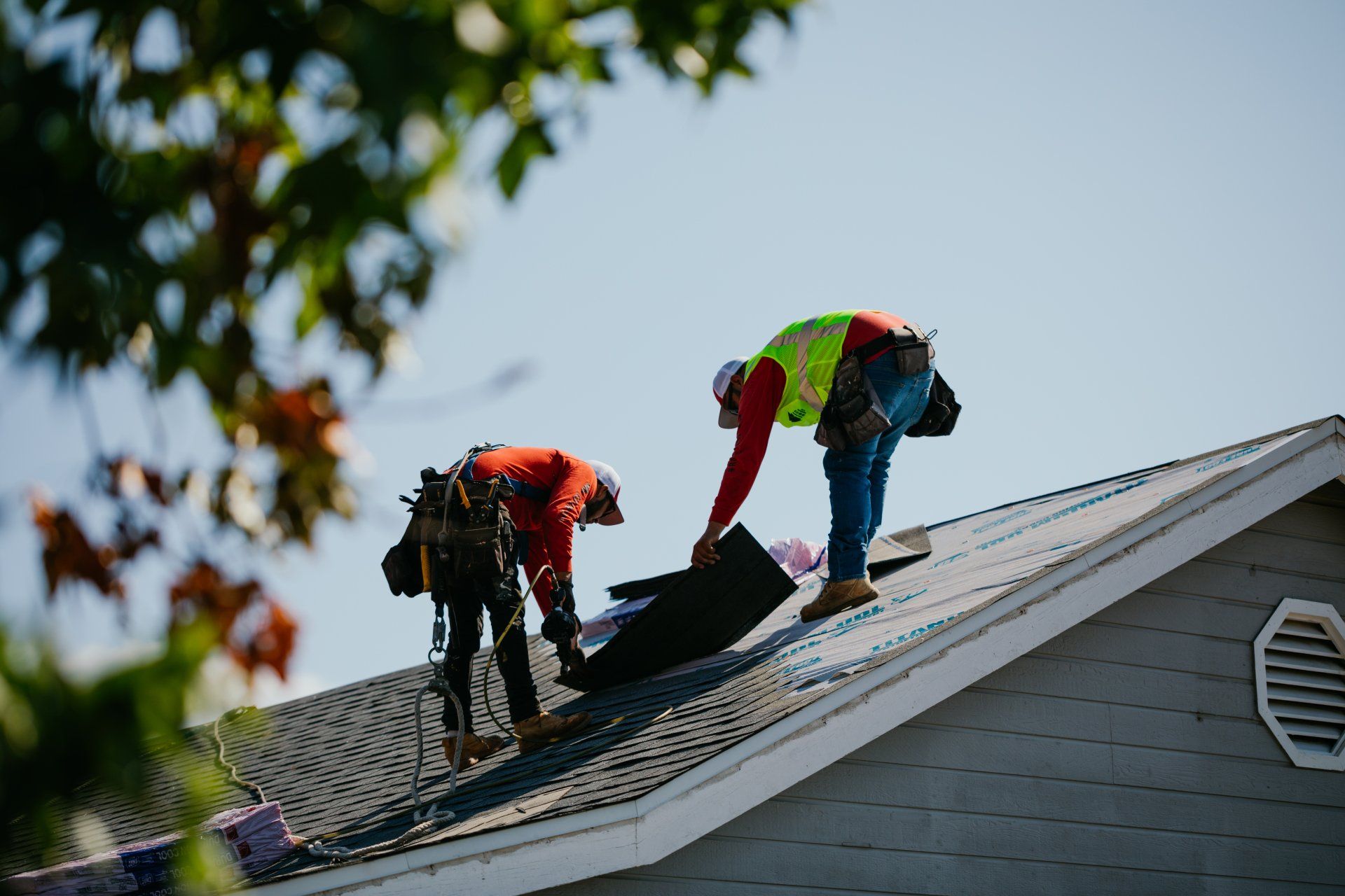 Two men are working on the roof of a house