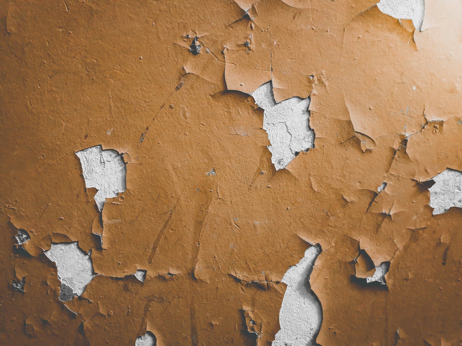 A close up of a brown wall with peeling paint