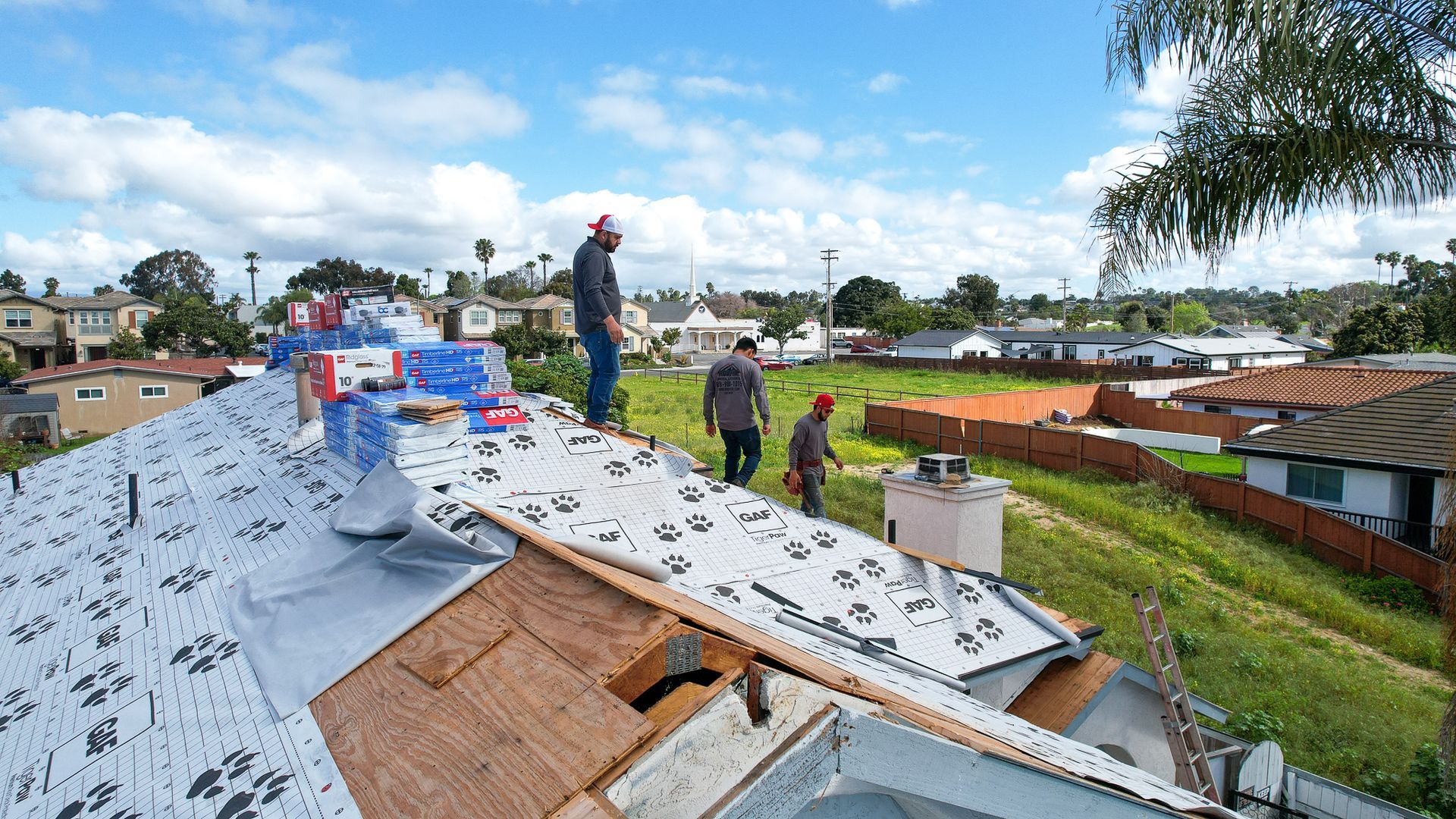 A group of men are working on the roof of a house