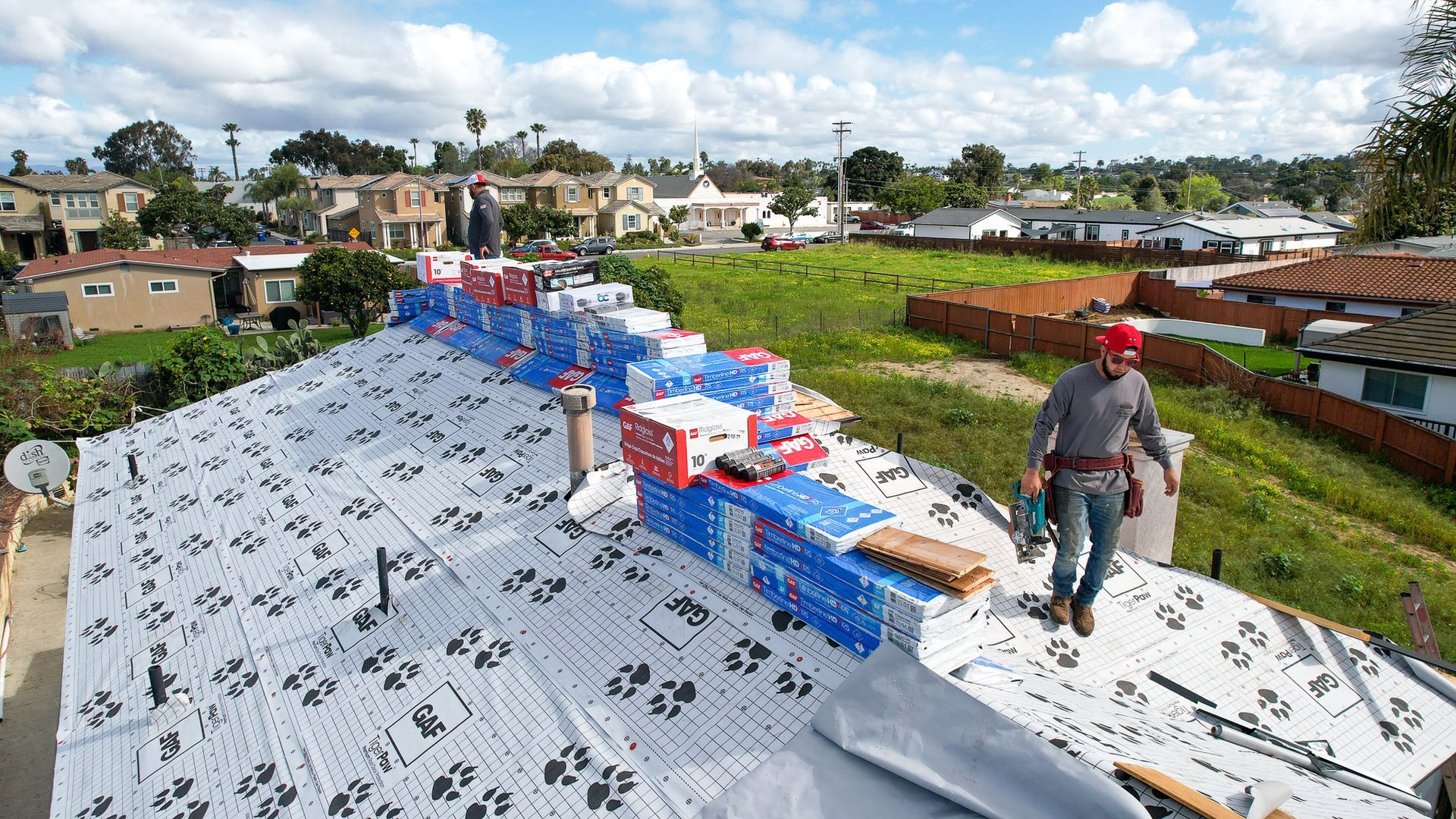 A man standing on top of a roof with boxes on it