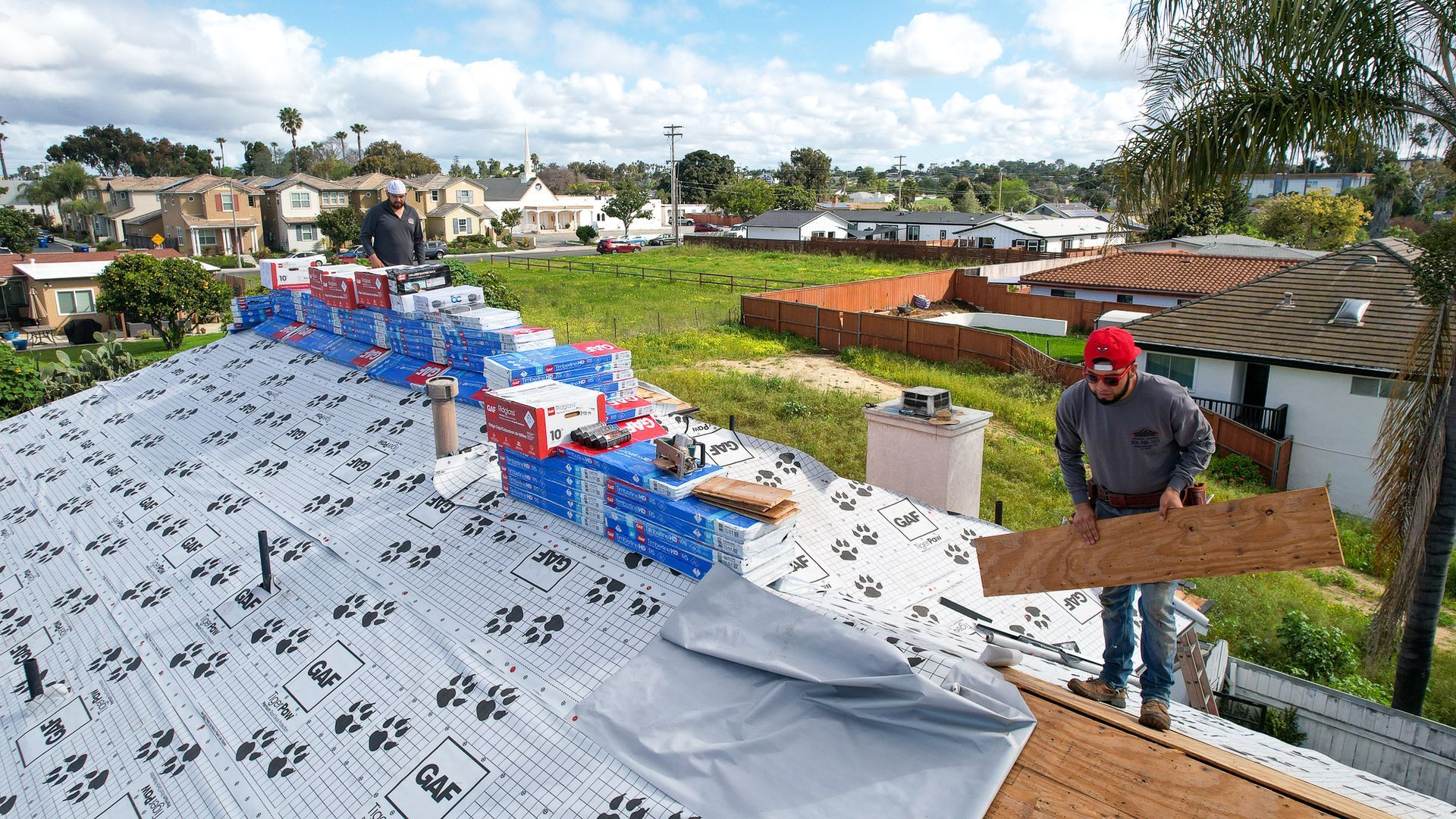 A man is working on the roof of a house