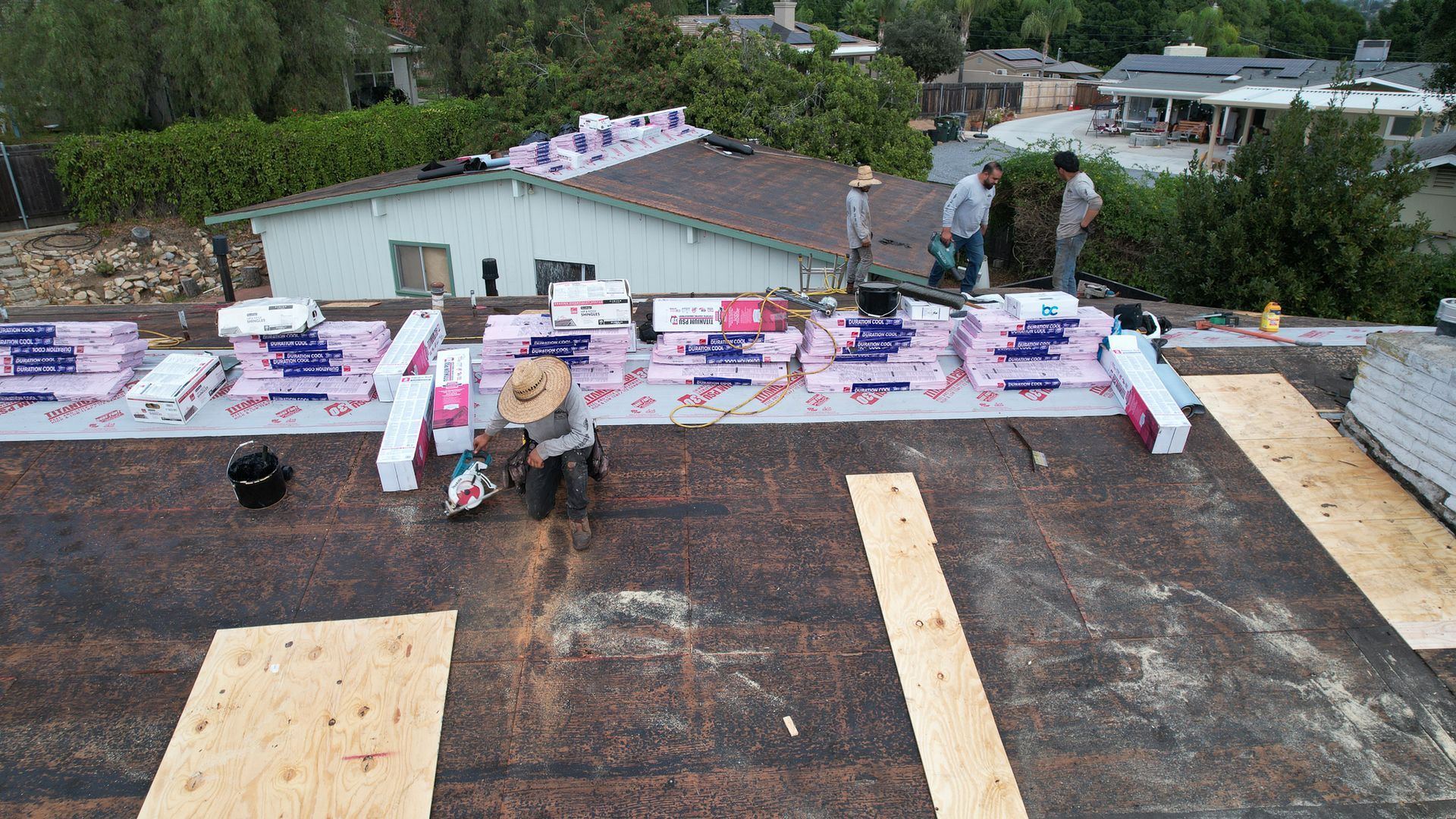 A roof is being repaired with a lot of supplies on it