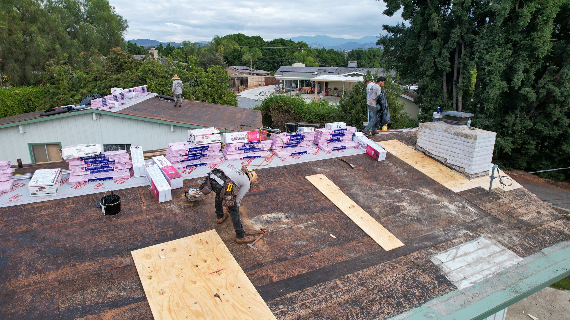 A man is working on the roof of a house