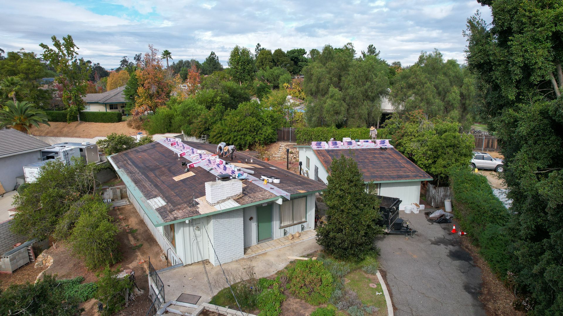 An aerial view of a house with a roof that is being repaired