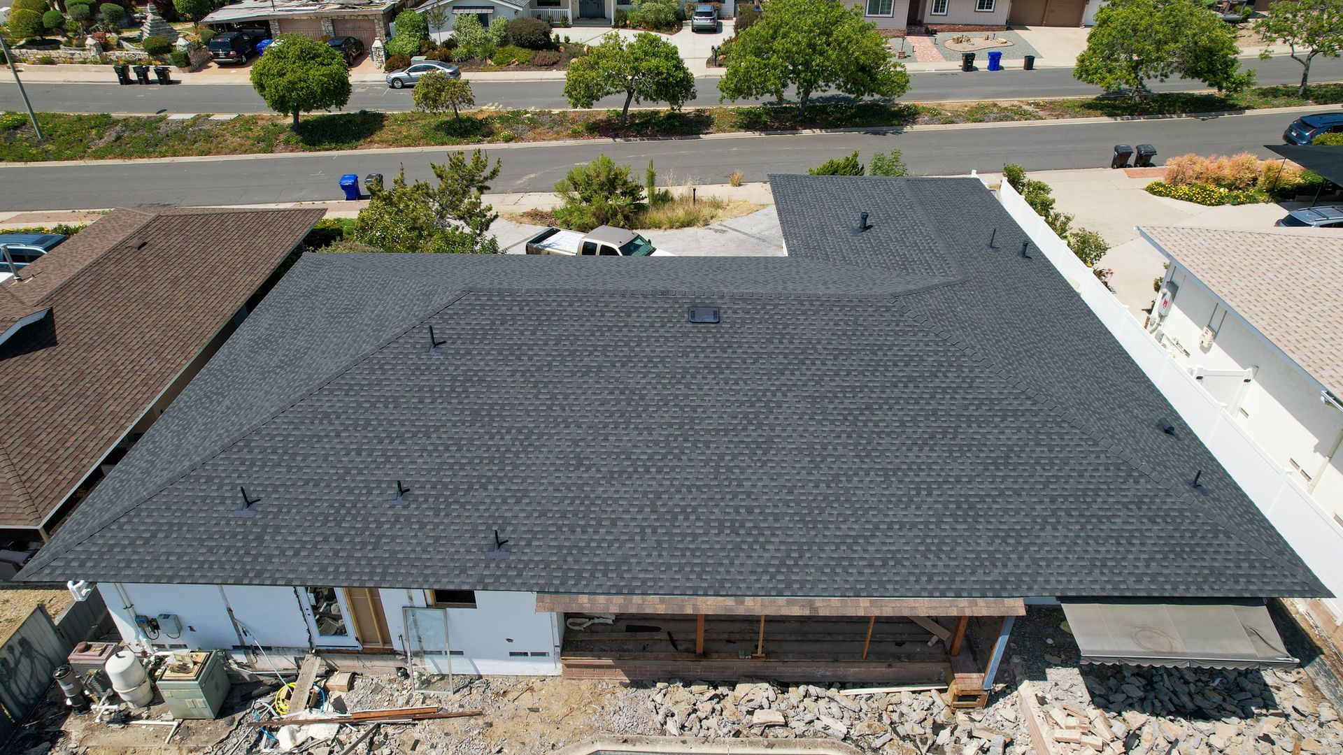 An aerial view of a house under construction with a black roof
